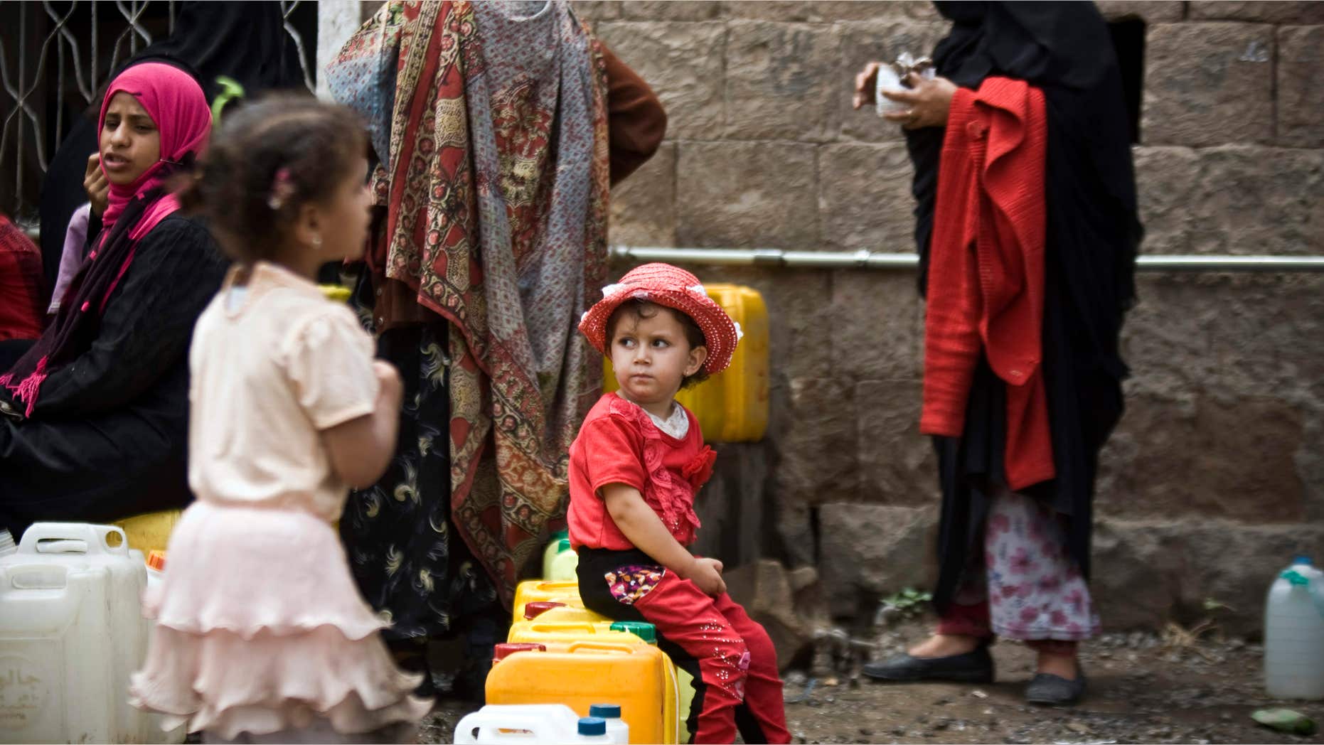 May 9, 2015: A girl waits for her turn to fill buckets with water from a public tap amid an acute shortage of water, in Sanaa, Yemen.