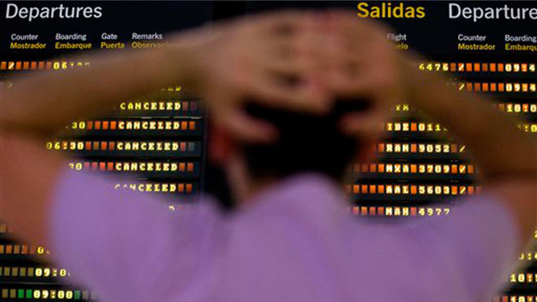 May 11: A passenger looks at a flight departure screen showing all flights canceled at the international airport in Seville, Spain.
