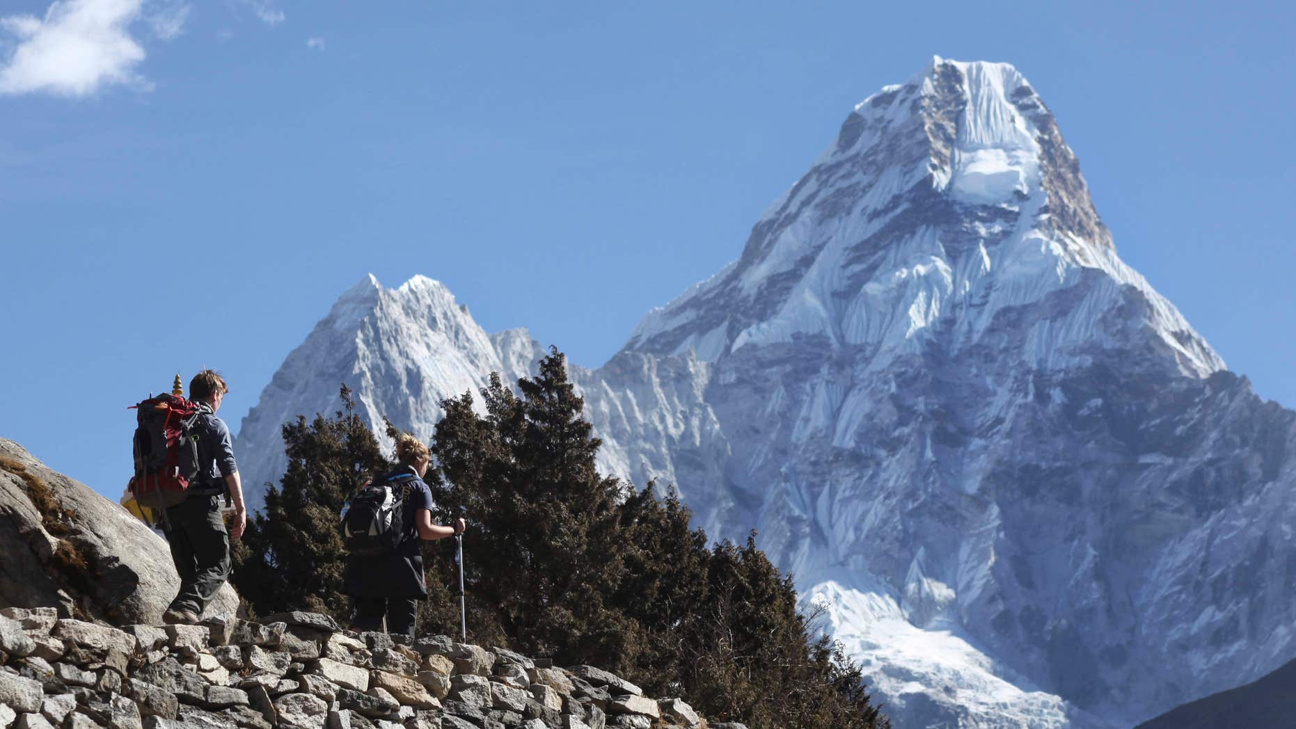 FILE - In this Feb. 19, 2016, file photo, trekkers make their way to Dingboche, a popular Mount Everest base camp, in Pangboche, Nepal.