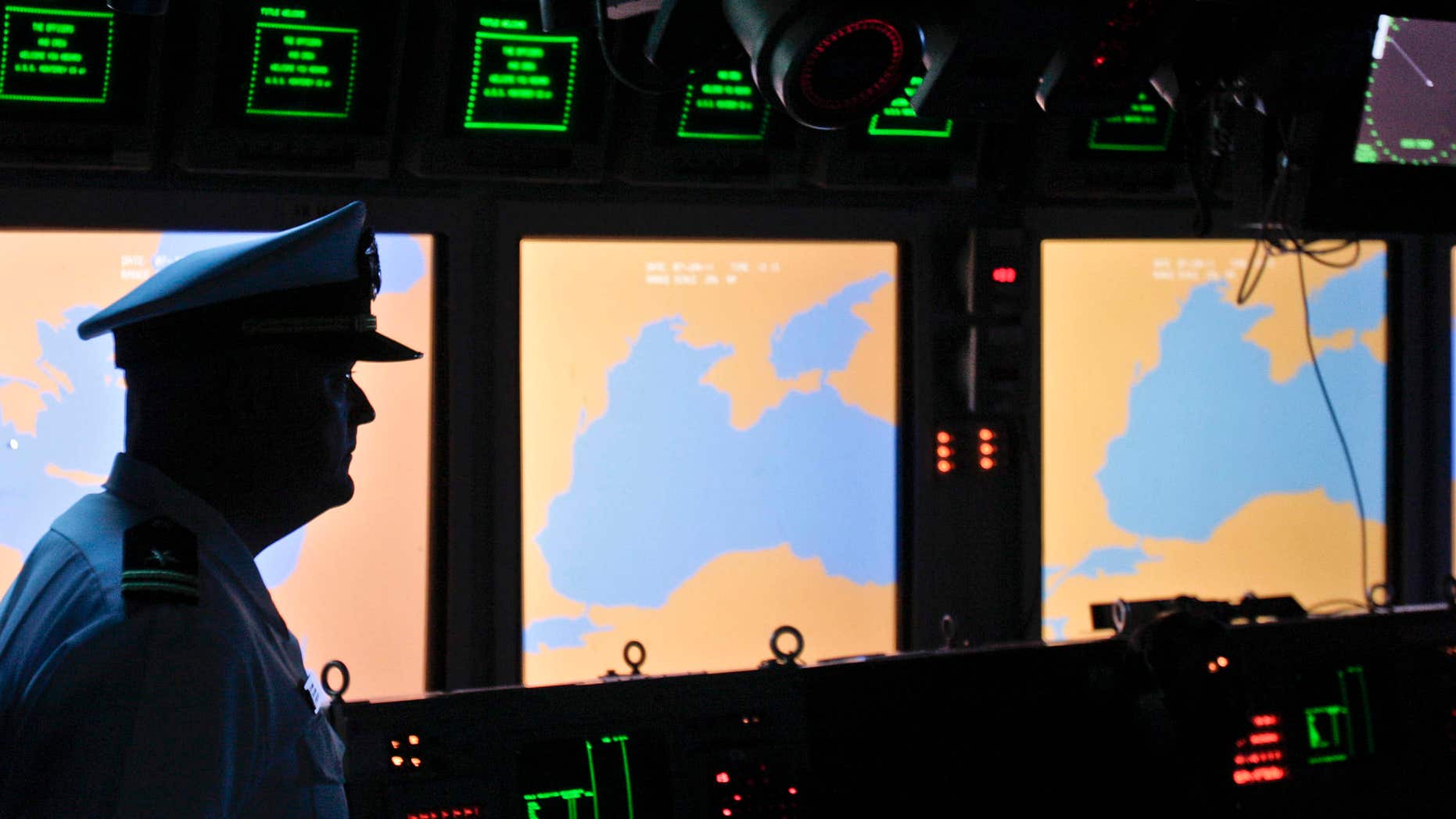 FILE- In this Tuesday, June 7, 2011 file photo, a US Navy officer, name not available, stands on the weapons control deck of the USS Monterey as screens display the Black Sea region, in the Black Sea port of Constanta, Romania.