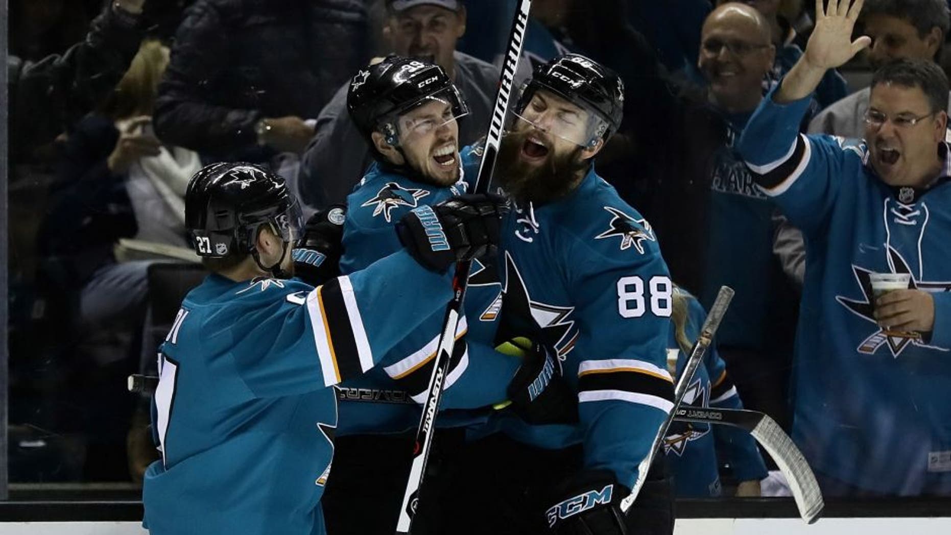 SAN JOSE, CA - MAY 12: Logan Couture #39 of the San Jose Sharks is congratulated by Brent Burns #88 and Joonas Donskoi #27 after Couture scored in the second period against the Nashville Predators in Game Seven of the Western Conference Second Round during the 2016 NHL Stanley Cup Playoffs at SAP Center on May 12, 2016 in San Jose, California. (Photo by Ezra Shaw/Getty Images)