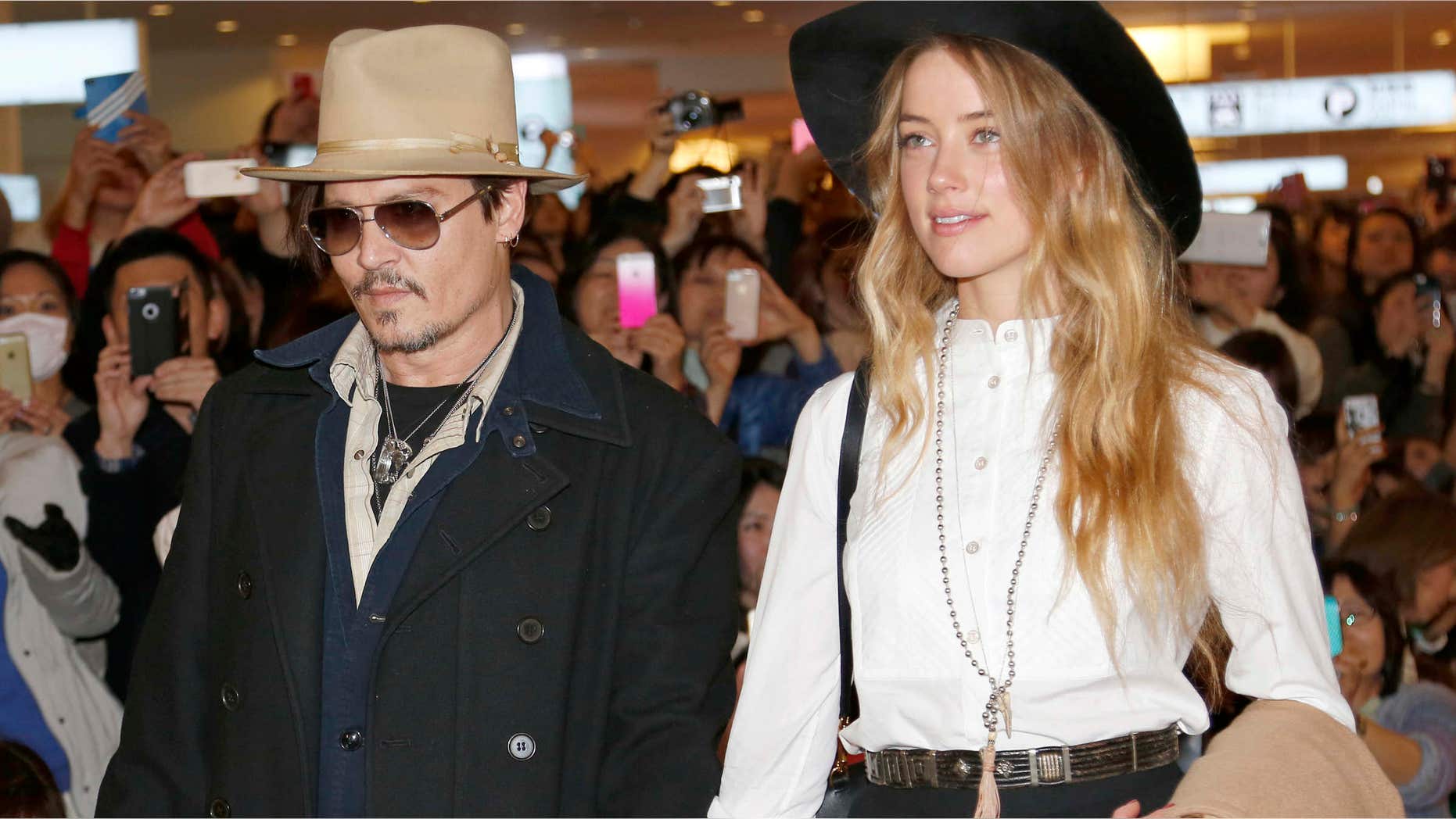 Jabn. 26, 2015: U.S. actor Johnny Depp and Amber Heard arrive at Haneda international airport in Tokyo to promote his latest film "Mortdecai."