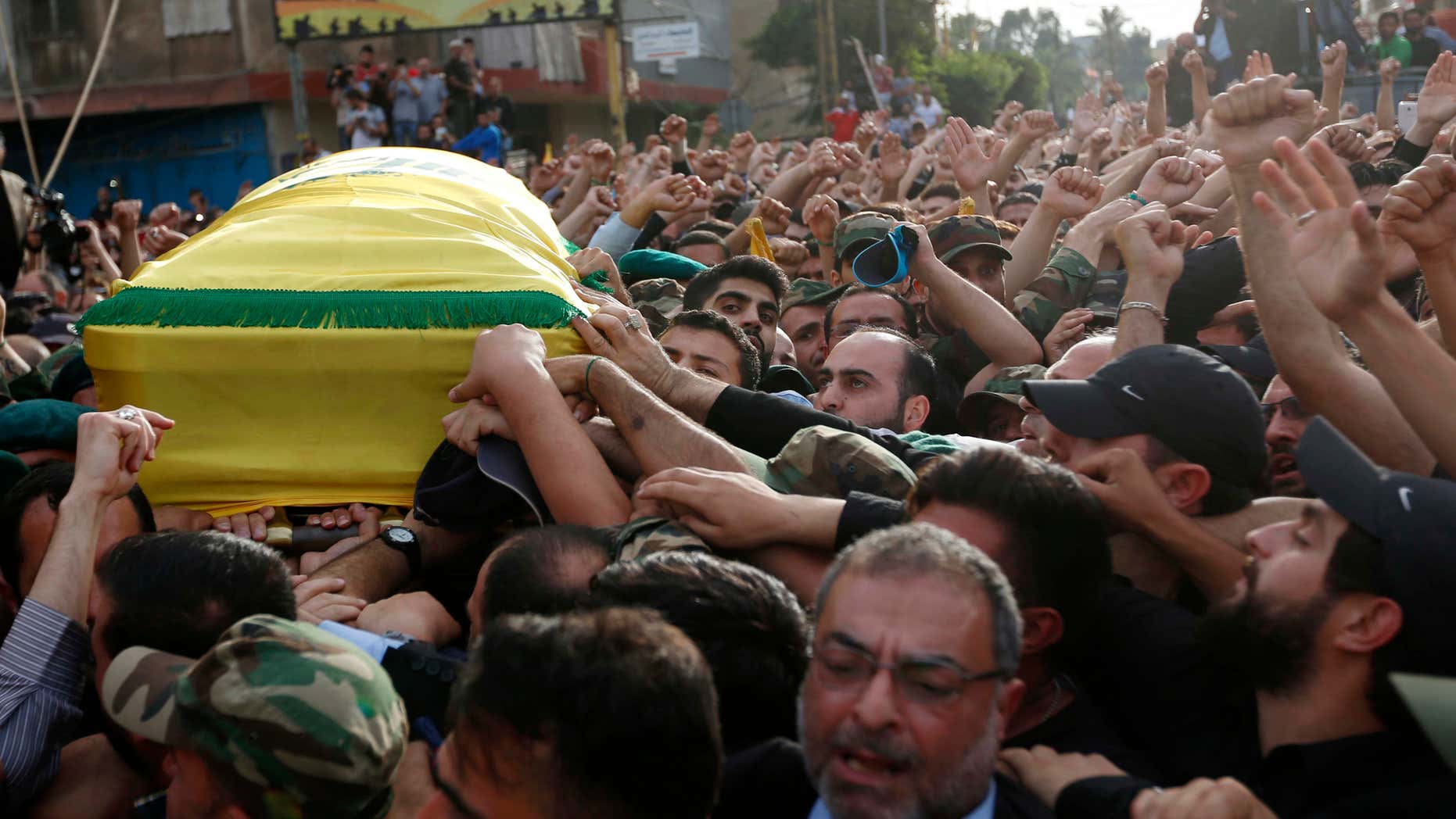 May 13, 2016: Hezbollah supporters carry the coffin of their slain commander Mustafa Badreddine, draped in a Hezbollah flag, during his funeral procession in a southern suburb of Beirut, Lebanon.
