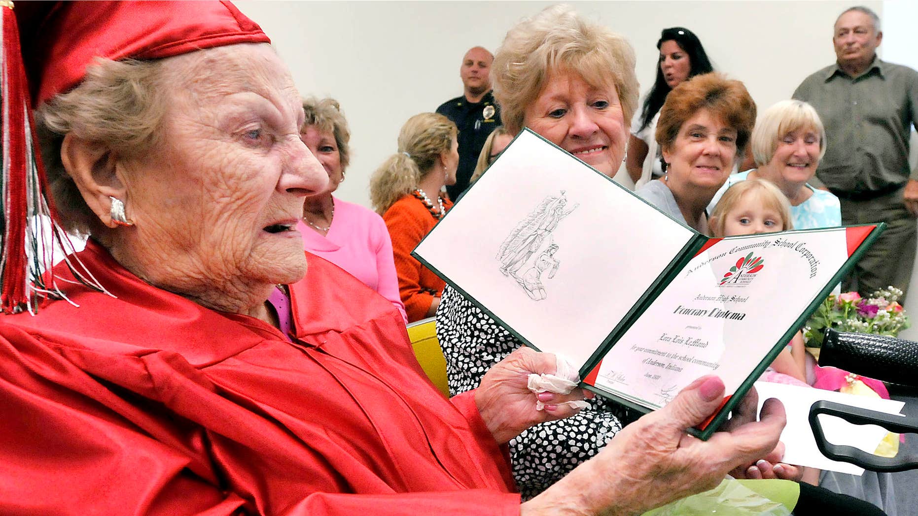 May 12, 2015: Wearing her cap & gown Lora Lois LeMond White Hardy, 99, looks over the honorary diploma from Anderson High School in Anderson, Ind.