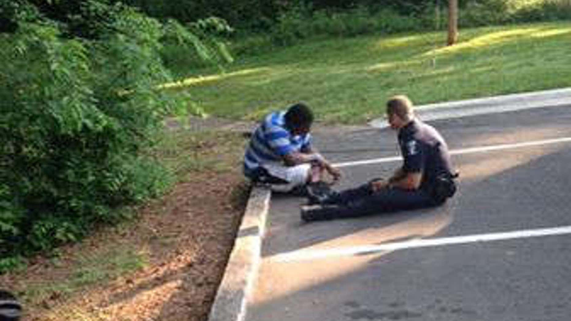 Photo shows Officer Tim Purdy talking with autistic high school student.