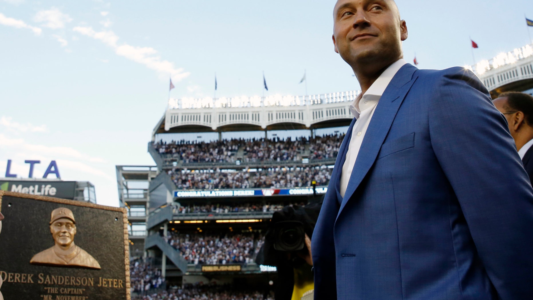 Retired New York Yankees shortstop Derek Jeter, right, looks around during a pregame ceremony after his No. 2 was retired in Monument Park at Yankee Stadium in New York, Sunday, May 14, 2017.