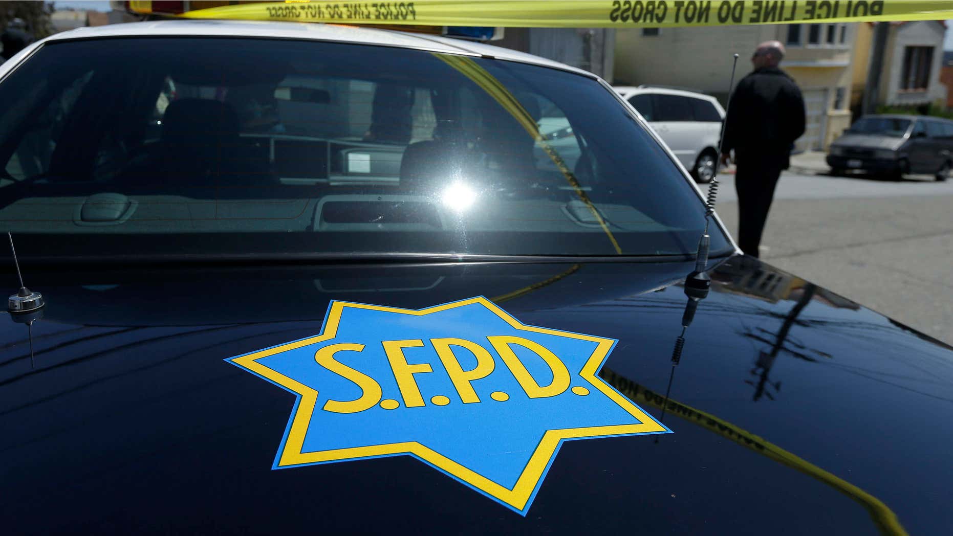 May 12, 2015: a San Francisco Police officer walks past a patrol car parked in San Francisco.