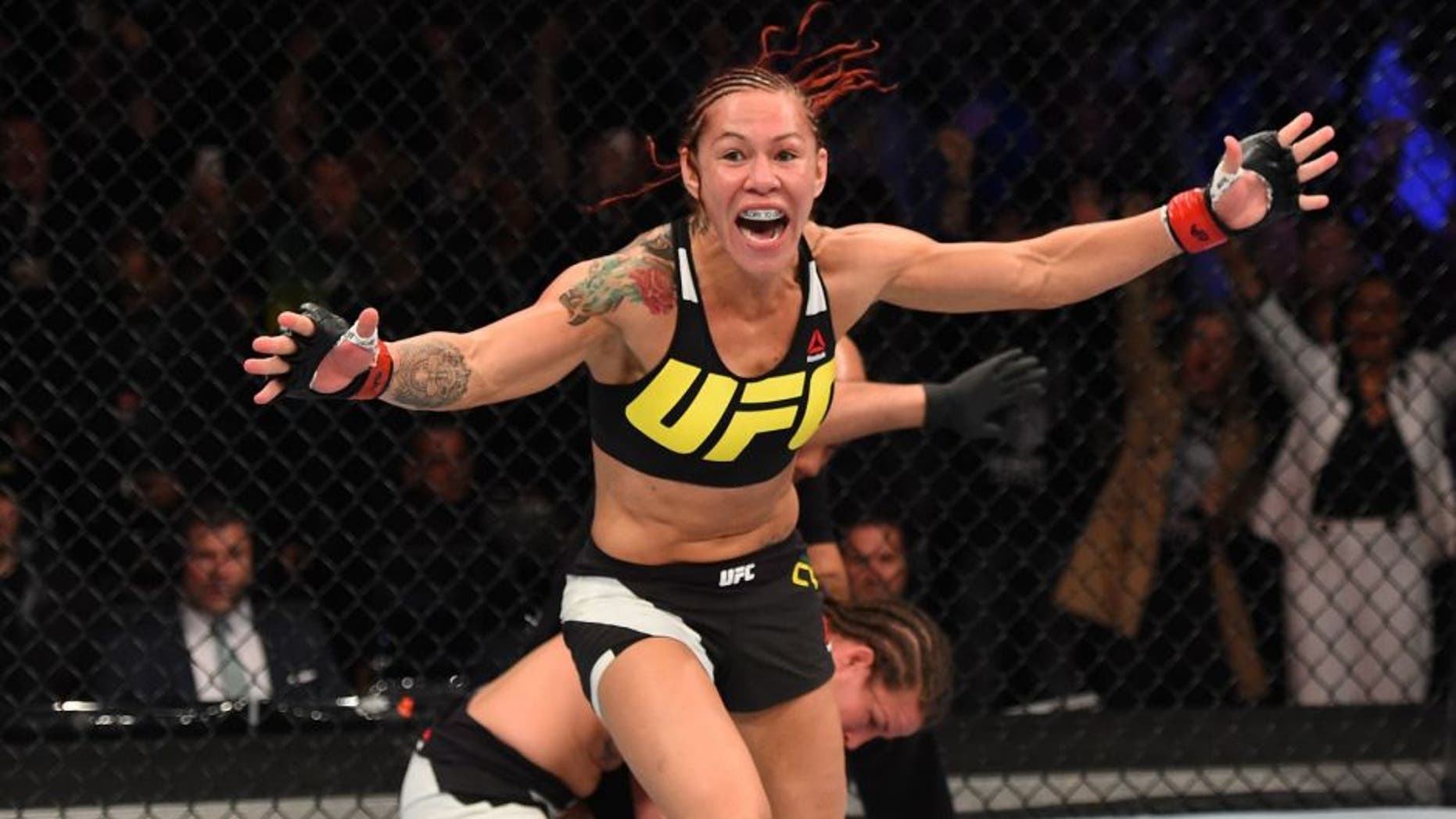 CURITIBA, BRAZIL - MAY 14: (L-R) Cristiane 'Cyborg' Justino of Brazil celebrates after defeating Leslie Smith in their women's catchweight bout during the UFC 198 event at Arena da Baixada stadium on May 14, 2016 in Curitiba, Parana, Brazil. (Photo by Josh Hedges/Zuffa LLC/Zuffa LLC via Getty Images)