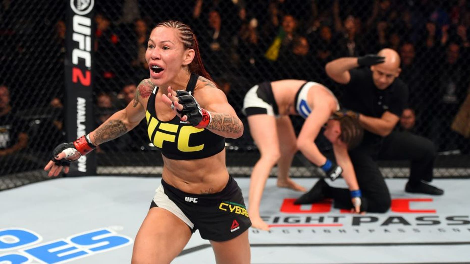CURITIBA, BRAZIL - MAY 14: (L-R) Cristiane 'Cyborg' Justino of Brazil celebrates after defeating Leslie Smith in their women's catchweight bout during the UFC 198 event at Arena da Baixada stadium on May 14, 2016 in Curitiba, Parana, Brazil. (Photo by Josh Hedges/Zuffa LLC/Zuffa LLC via Getty Images)