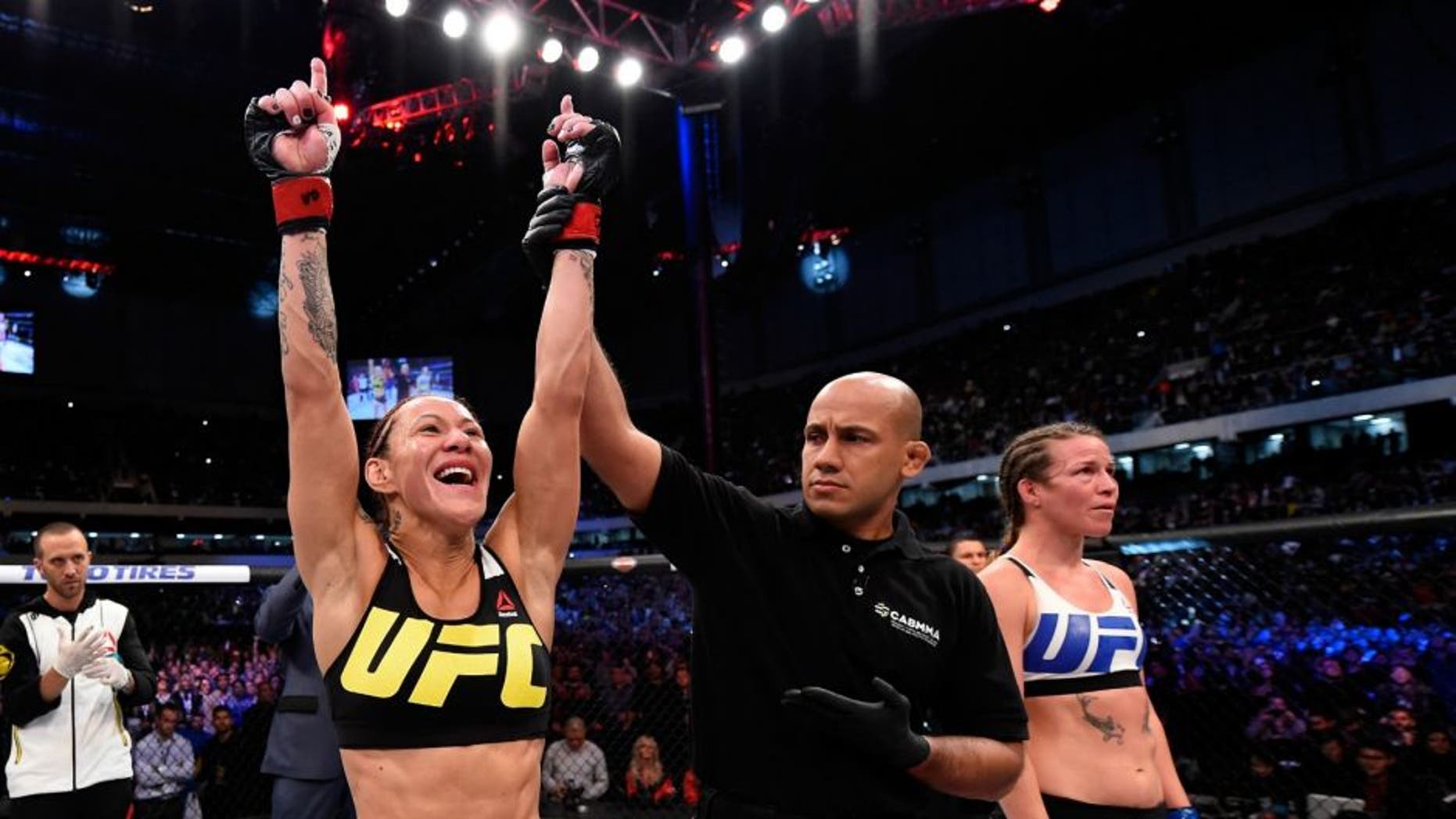 CURITIBA, BRAZIL - MAY 14: (L-R) Cristiane 'Cyborg' Justino of Brazil celebrates after defeating Leslie Smith in their women's catchweight bout during the UFC 198 event at Arena da Baixada stadium on May 14, 2016 in Curitiba, Parana, Brazil. (Photo by Josh Hedges/Zuffa LLC/Zuffa LLC via Getty Images)