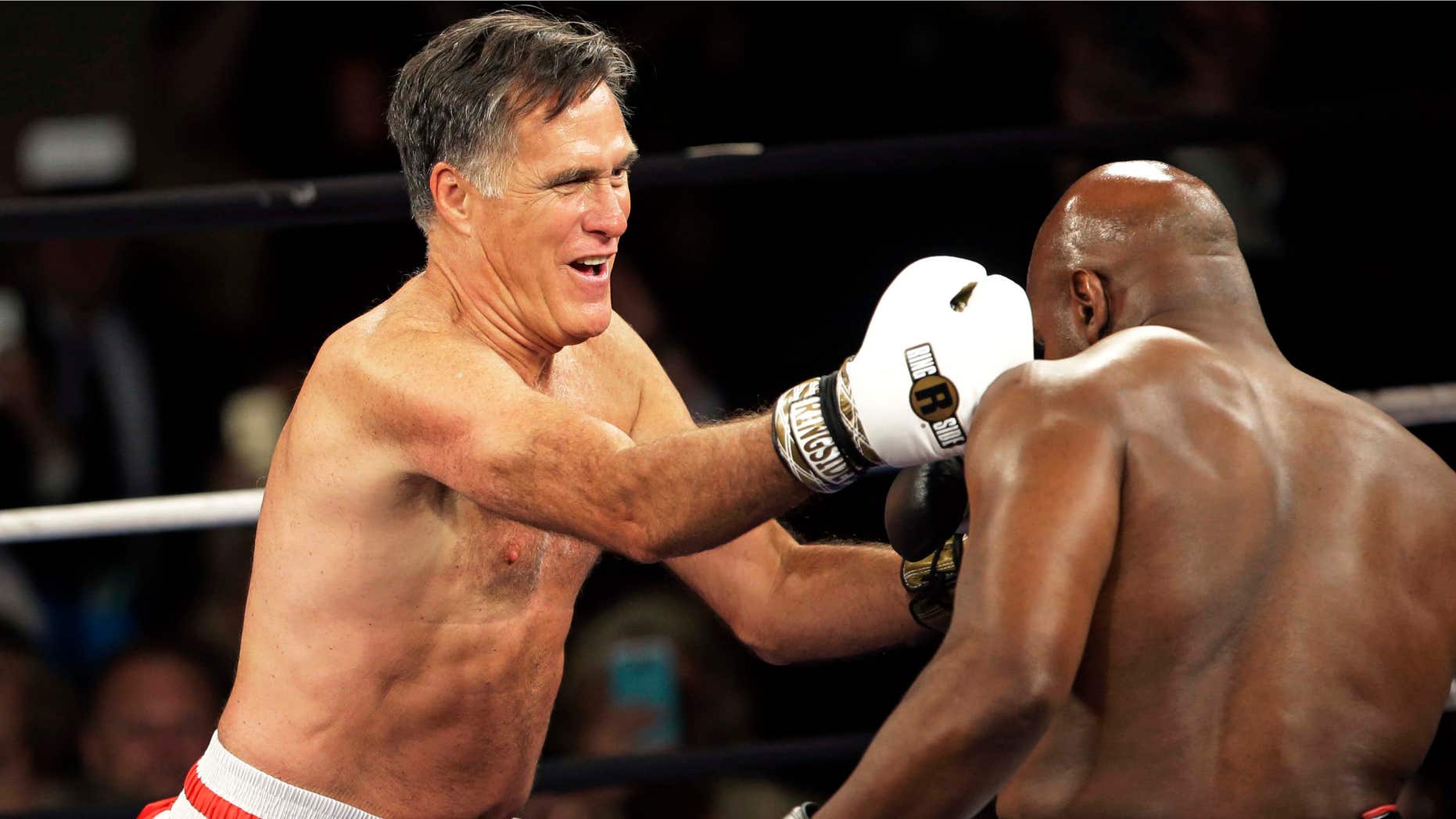 May 15, 2015: Former Republican presidential candidate Mitt Romney, left, lands a punch against five-time heavyweight boxing champion Evander Holyfield at a charity fight night event.