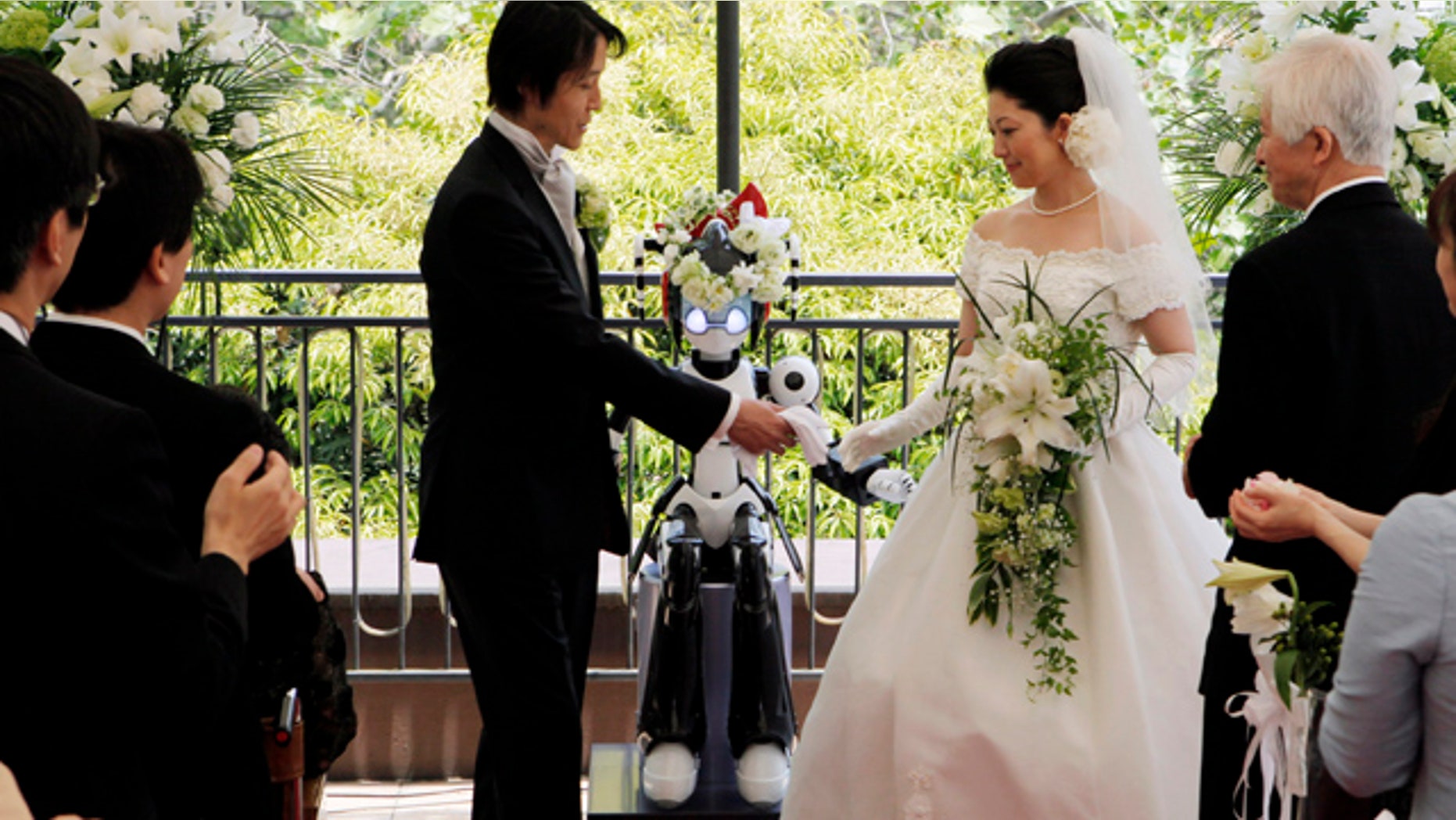 May 16: The 'I-Fairy' wears a wreath of flowers as it directs a wedding ceremony for groom Tomohiro Shibata 42, and bride Satoko Inouye, 36, at a Tokyo restaurant.