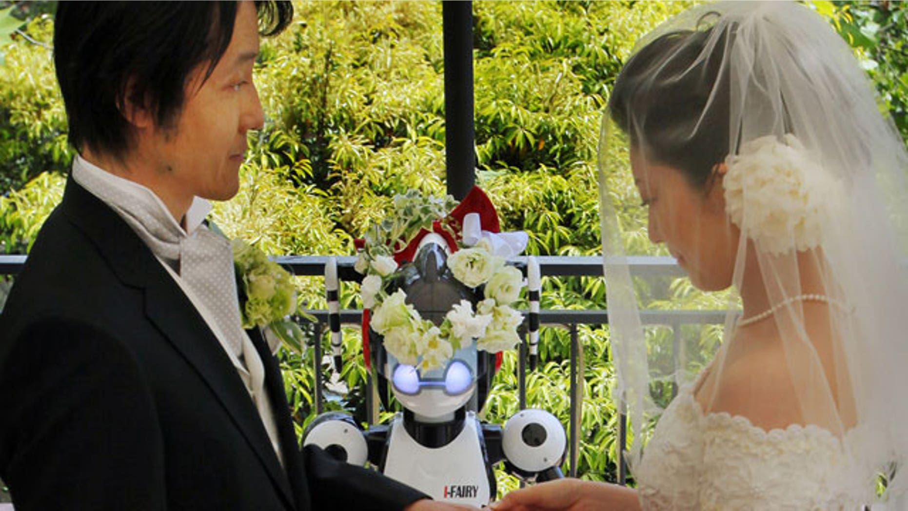 May 16: Bride Satoko Inouye, 36, puts a ring on a finger of her groom Tomohiro Shibata 42, as I-Fairy, a four-foot tall seated robot, wearing a wreath of flowers, directs their wedding ceremony at a Tokyo restaurant.