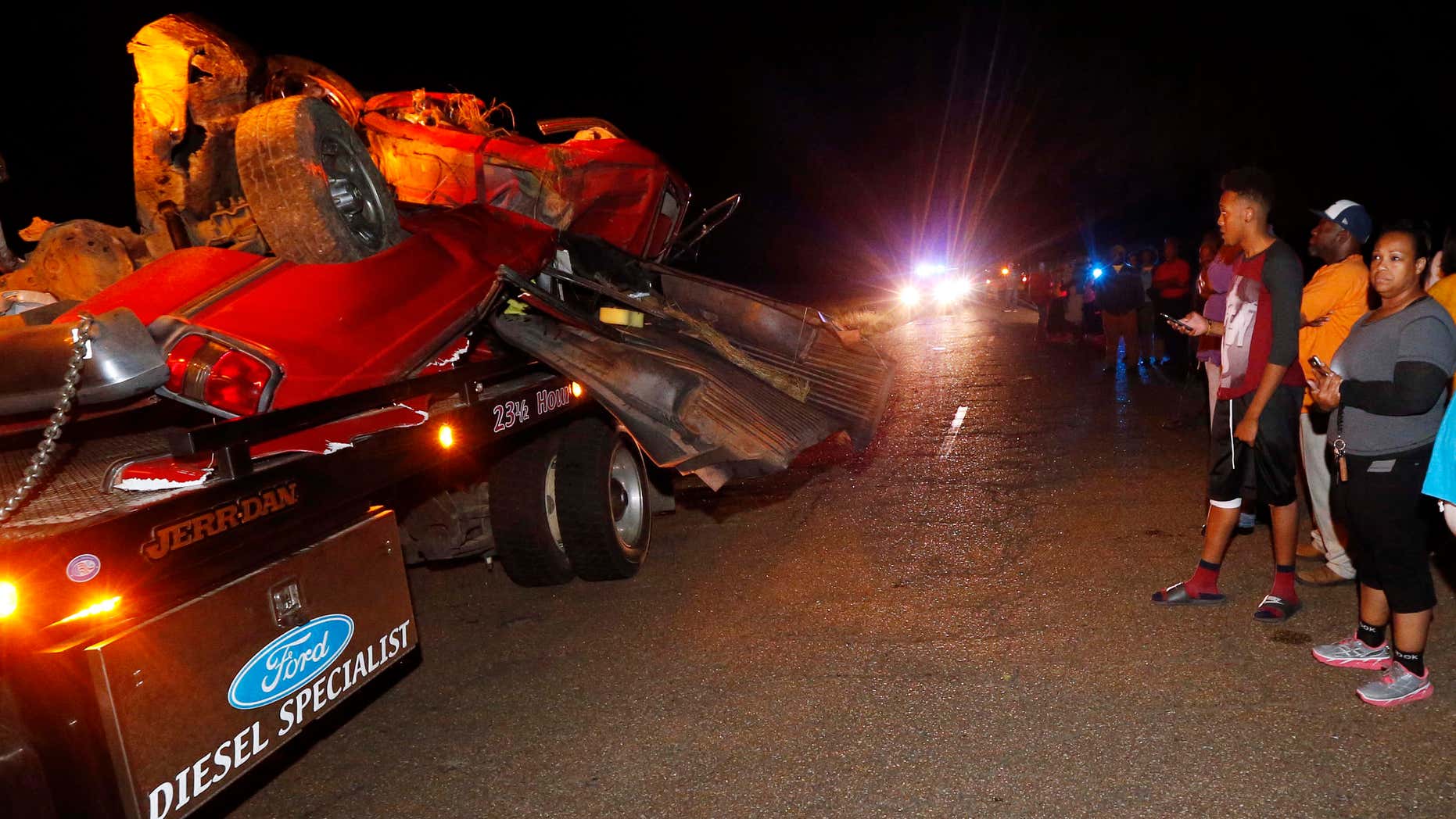 May 18, 2016: Friends and relatives walk past the remains of a pickup truck that collided with Amtrak's "City of New Orleans" passenger train in Flora, Miss..