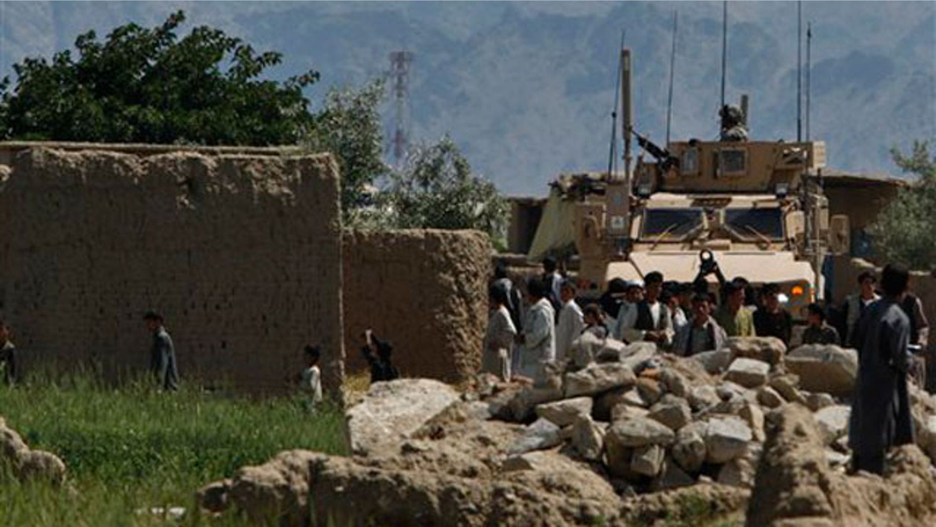 May 19: U.S soldiers wait after collecting the body of an insurgent from a vineyard near the Bagram airbase after insurgents launched a brazen pre-dawn assault against the giant U.S.-run air field in Afghanistan.