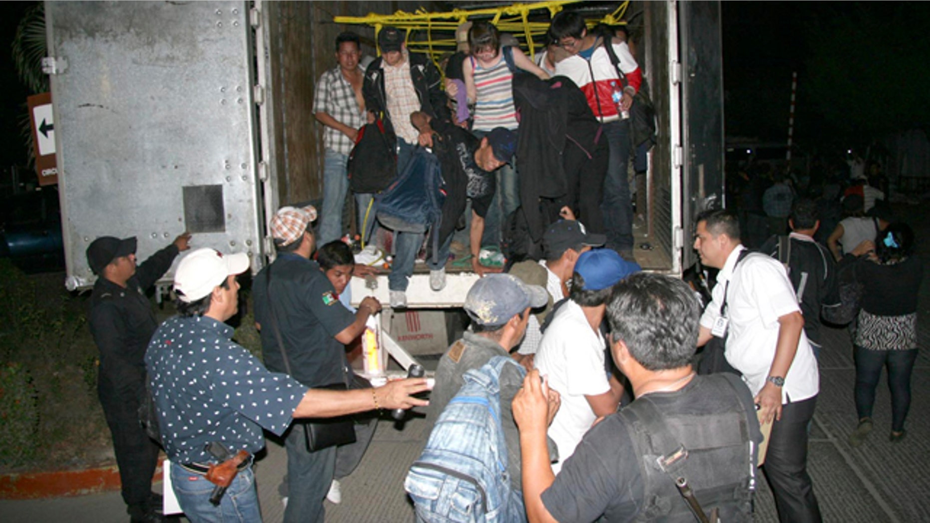 May 17: In this photo released by Chiapas State Attorney General, migrants from Latin America and Asia leave a truck that was heading to the U.S. after being detected by an X-ray equipment at a checkpoint near Tuxtla Gutierrez, in Mexico's southern Chiapas state.