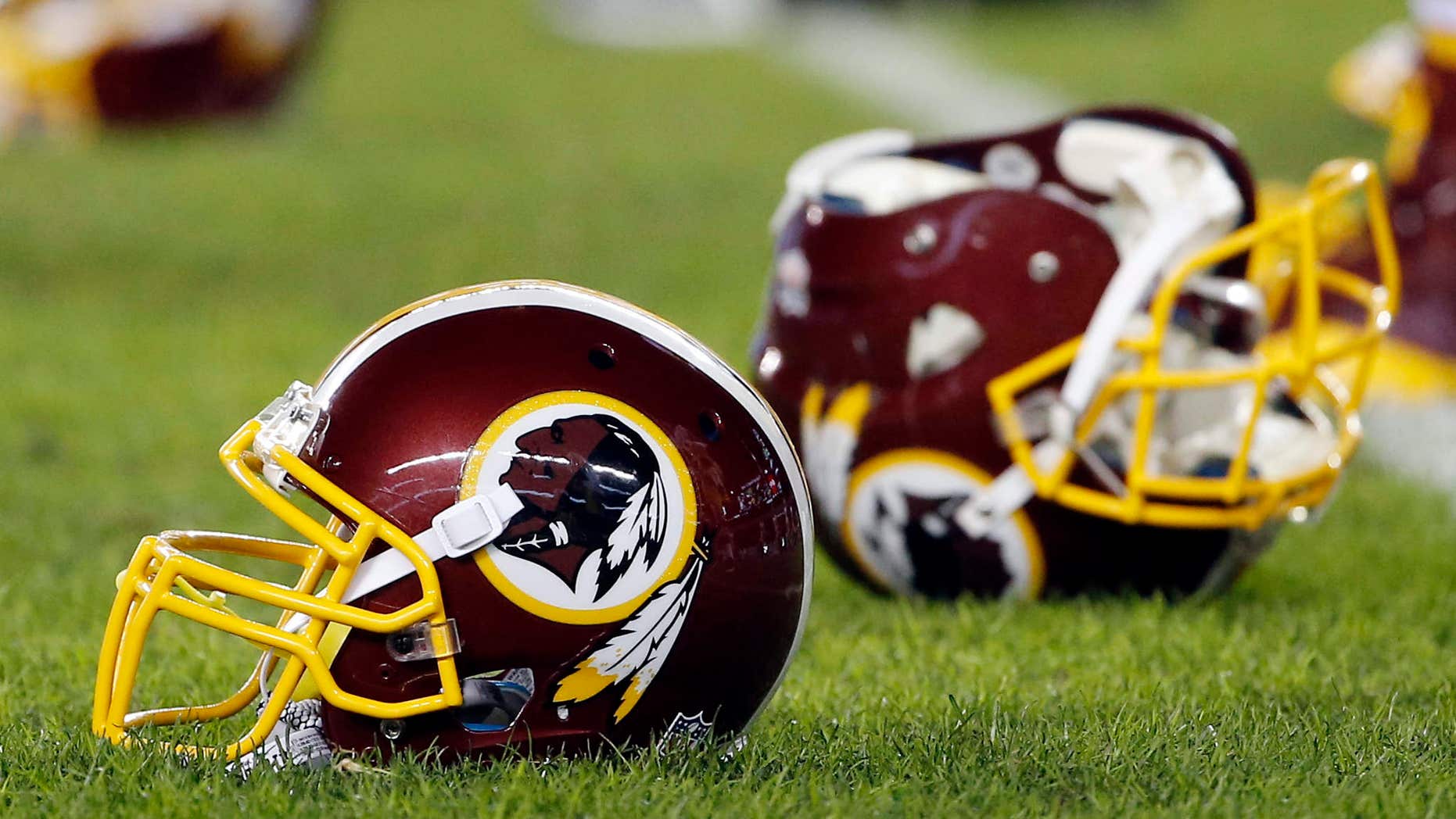 FILE - In this Dec. 26, 2015, file photo, a Washington Redskins helmet sits on the field as players warm-up before an NFL football game against the Philadelphia Eagles in Philadelphia.