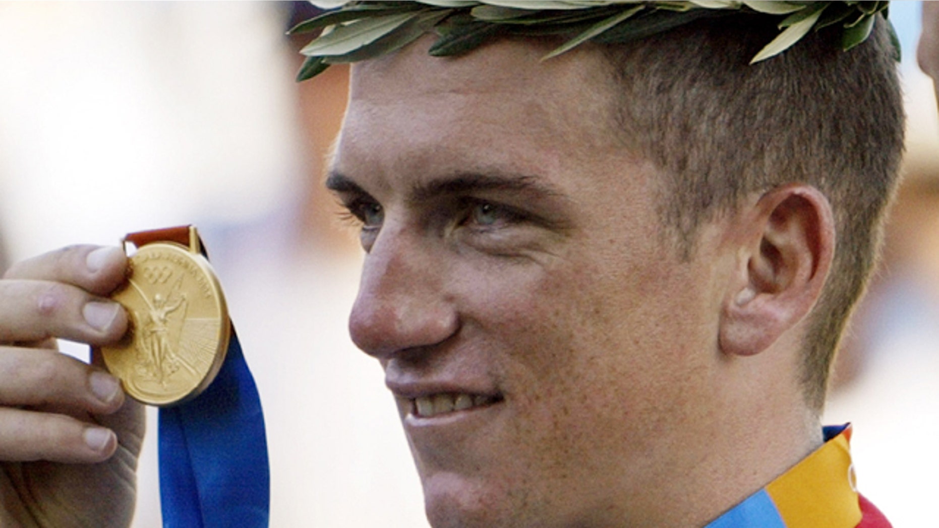 This Aug. 18, 2004, file photo shows Tyler Hamilton of the U.S. holding up his gold medal after the men's road individual time trial of the 2004 Olympic Games in the outskirts of Athens.