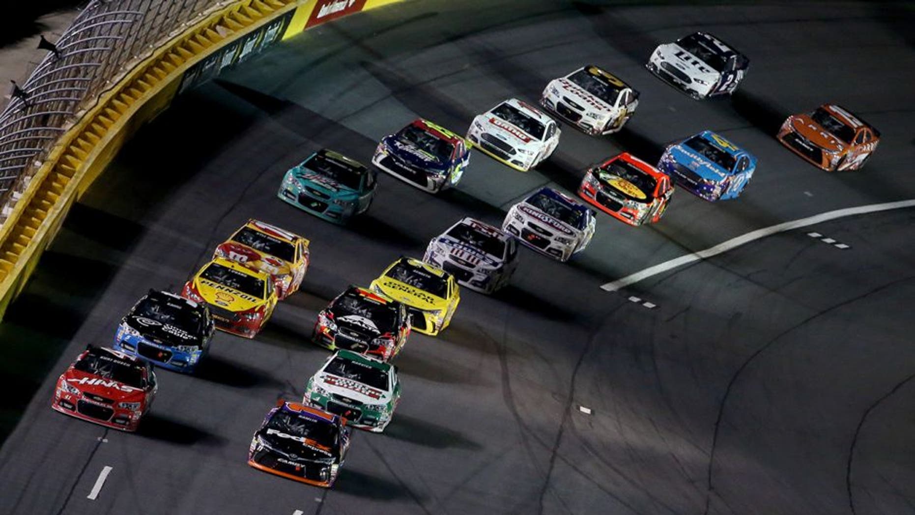 CHARLOTTE, NC - MAY 16: Denny Hamlin, driver of the #11 FedEx Express Toyota, and Kurt Busch, driver of the #41 Haas Automation Chevrolet, lead the field in a restart the NASCAR Sprint Cup Series Sprint All-Star Race at Charlotte Motor Speedway on May 16, 2015 in Charlotte, North Carolina. (Photo by Brian Lawdermilk/Getty Images)