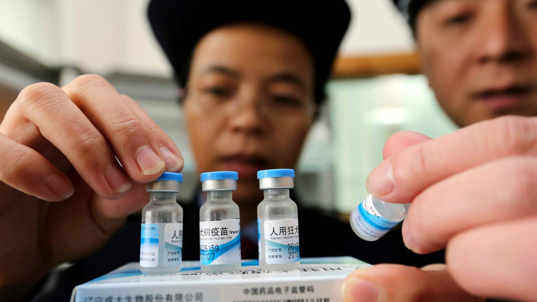 FILE - In this Monday, March 21, 2016 file photo, officials from China's State Food and Drug Administration inspect vaccines stored at the local Center for Disease Control and Prevention office in Rong'an county in southwestern China's Guangxi Zhuang Autonomous Region.