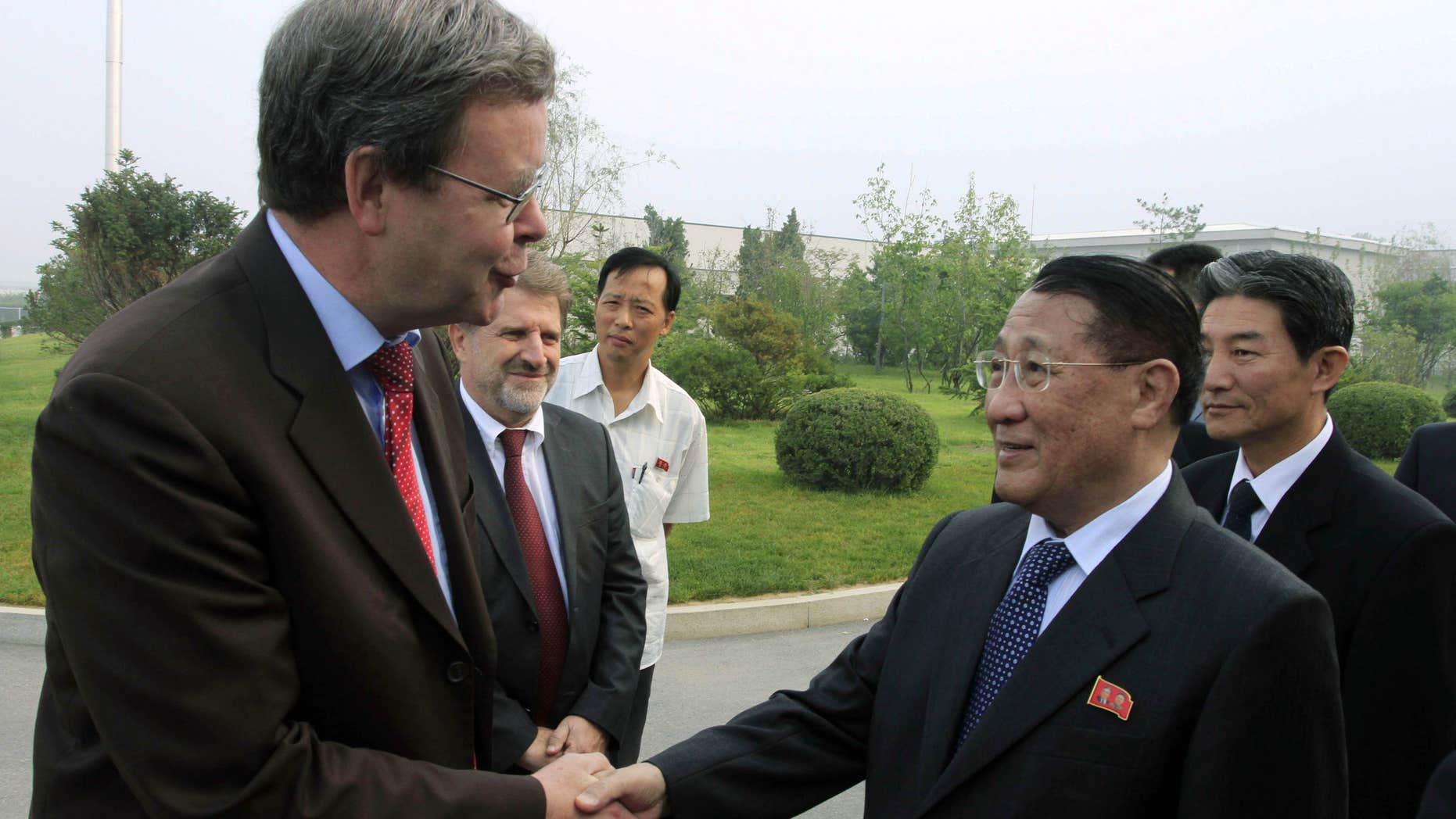 FILE - In this Sept. 6, 2014 file photo, North Korea's Kang Sok Ju, right, a member of the Political Bureau of the Central Committee of the Workers' Party of Korea (WPK) and secretary of the WPK, shakes hands with German Ambassador to North Korea Thomas Schaefer as he leaves Pyongyang Airport in Pyongyang, North Korea to visit Germany, Belgium, Switzerland, Italy and Mongolia.