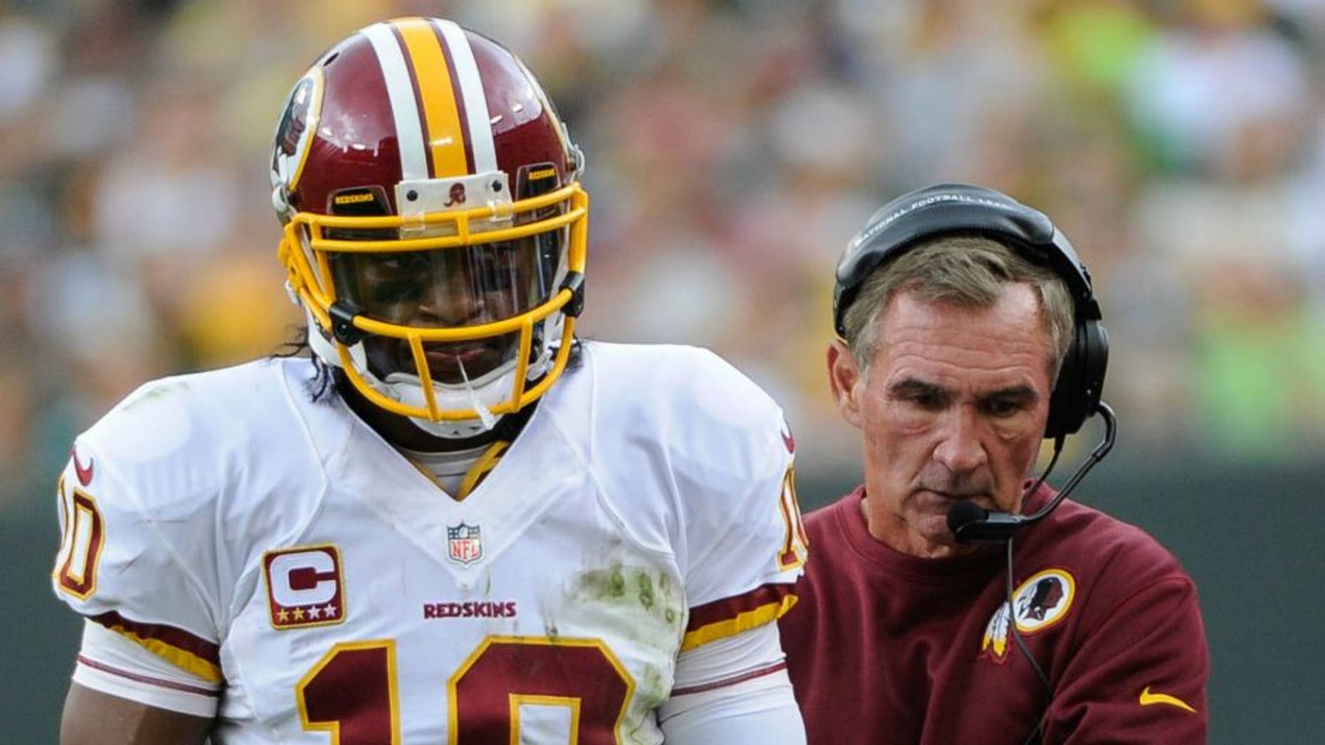 Sep 15, 2013; Green Bay, WI, USA; Washington Redskins quarterback Robert Griffin III (10) and head coach Mike Shanahan walk on the sidelines during the game against the Green Bay Packers in the third quarter at Lambeau Field. Mandatory Credit: Benny Sieu-USA TODAY Sports