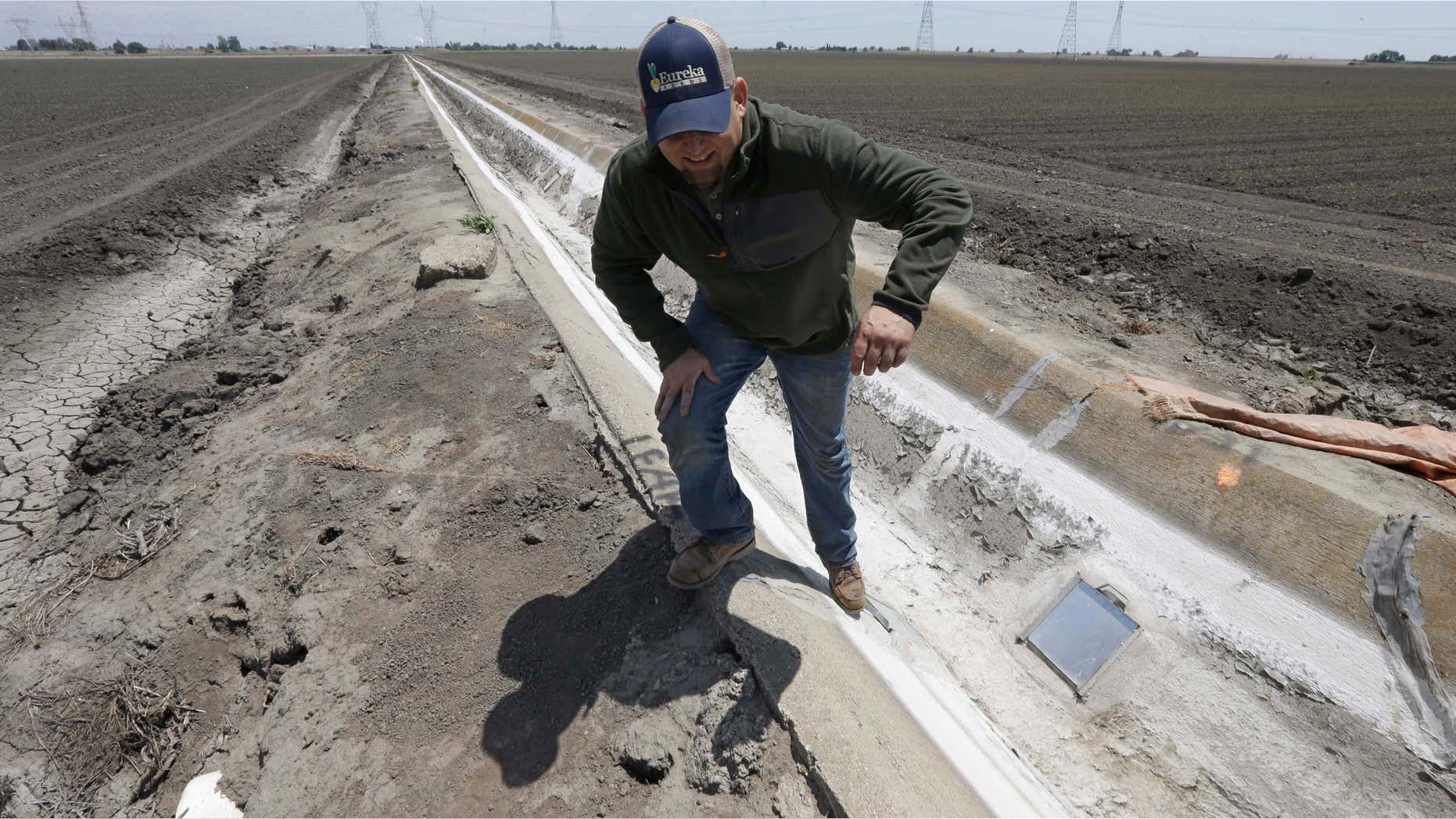 May 18, 2015: Farmer Gino Celli climbs out of a irrigation canal that is covered in dried salt on a field he farms near Stockton, Calif.