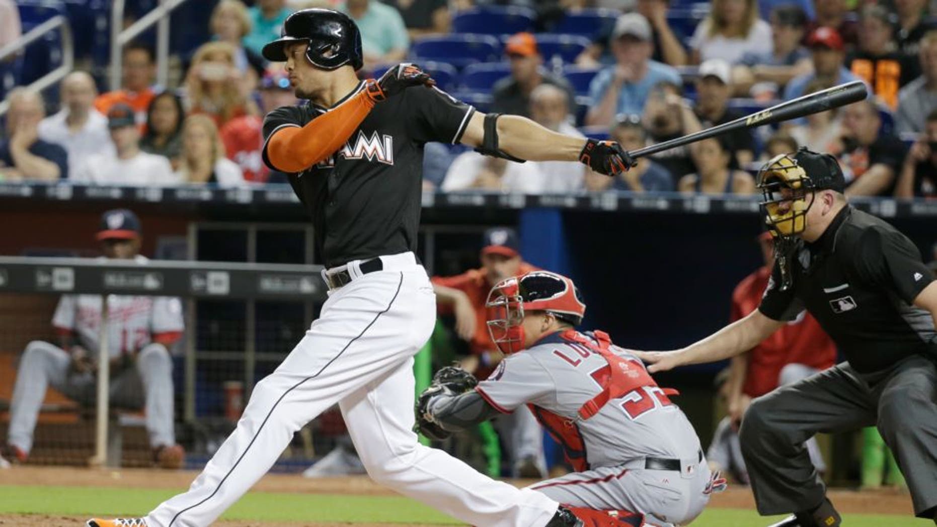 Miami Marlins' Giancarlo Stanton, left, strikes out during the first inning of a baseball game against the Washington Nationals, Saturday, May 21, 2016, in Miami. (AP Photo/Wilfredo Lee)