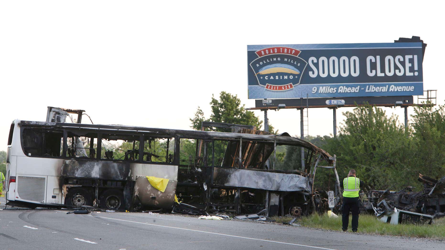April 11, 2014: A California Highway Patrol Officer photographs the crash scene where a tour bus and a FedEX truck crashed on Interstate 5 in Orland, Calif.