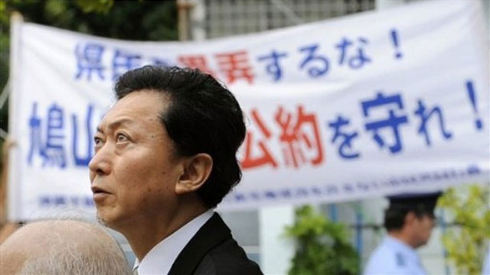 May 23: Japanese Prime Minister Yukio Hatoyama passes by a banner reading "Keep the promise" in Naha during his tour of Okinawa, Japan.