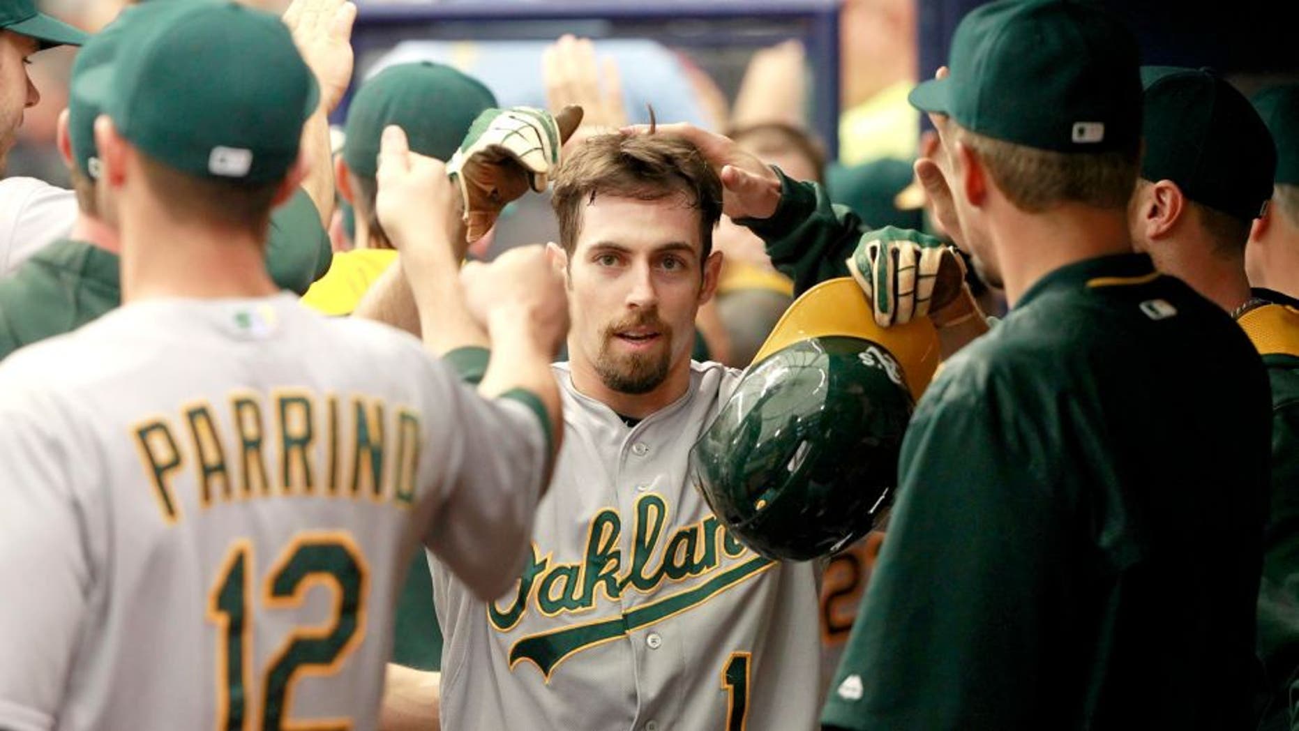 May 24, 2015; St. Petersburg, FL, USA; Oakland Athletics center fielder Billy Burns (1) is congratulated by teammates after he scored a run during the third inning against the Tampa Bay Rays at Tropicana Field. Mandatory Credit: Kim Klement-USA TODAY Sports
