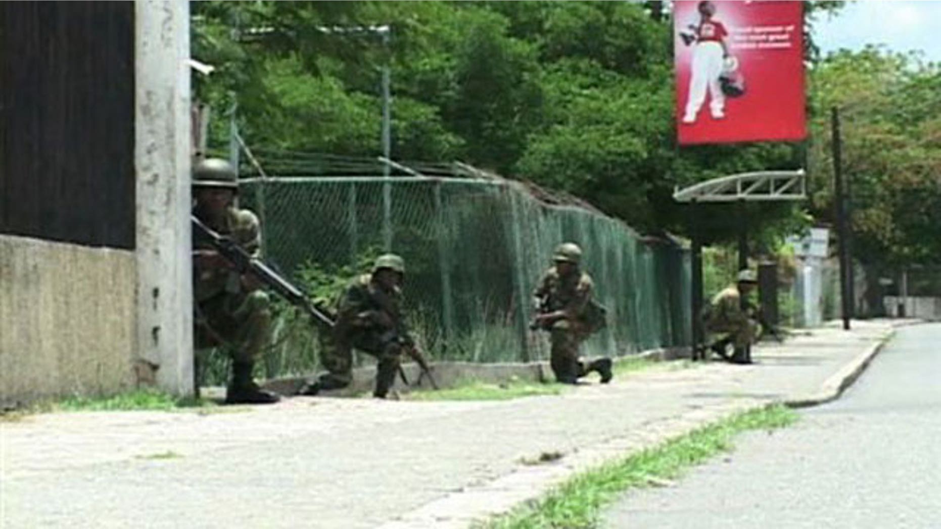 May 25: Jamaican army troops take cover during operations in Kingston, Jamaica, in search for reputed drug kingpin.