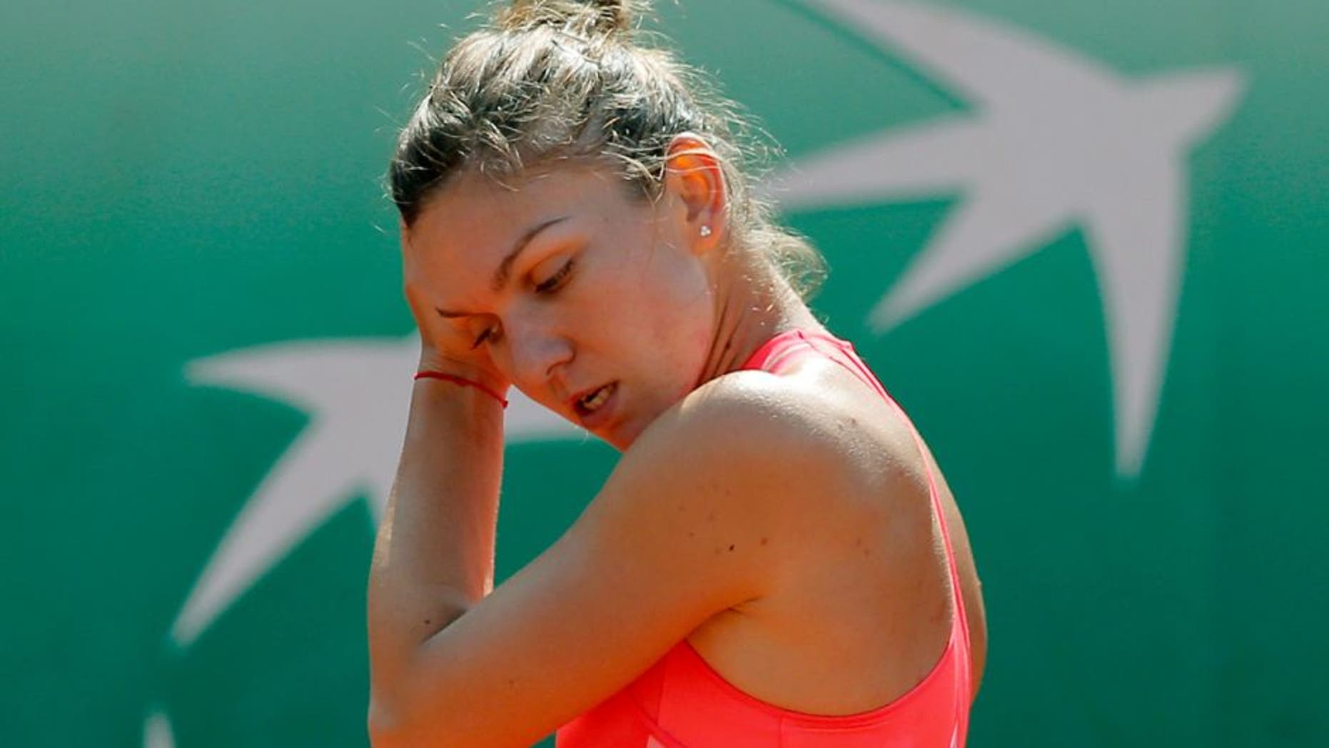 Romania's Simona Halep holds her head after missing a return in the second round match of the French Open tennis tournament against Croatia's Mirjana Lucic-Baroni at the Roland Garros stadium, in Paris, France, Wednesday, May 27, 2015. Lucic-Baroni won in two sets 7-5, 6-1. (AP Photo/Christophe Ena)