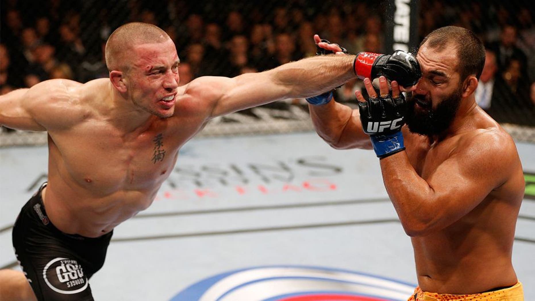 LAS VEGAS, NV - NOVEMBER 16: (L-R) Georges St-Pierre punches Johny Hendricks in their UFC welterweight championship bout during the UFC 167 event inside the MGM Grand Garden Arena on November 16, 2013 in Las Vegas, Nevada. (Photo by Josh Hedges/Zuffa LLC/Zuffa LLC via Getty Images)