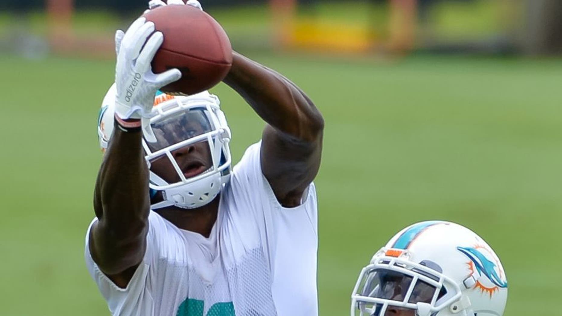 May 26, 2015; Miami, FL, USA; Miami Dolphins wide receiver DeVante Parker (11) makes a catch as Miami Dolphins cornerback Brent Grimes (21) defends during practice drills at Miami Dolphins Training Facility. Mandatory Credit: Steve Mitchell-USA TODAY Sports