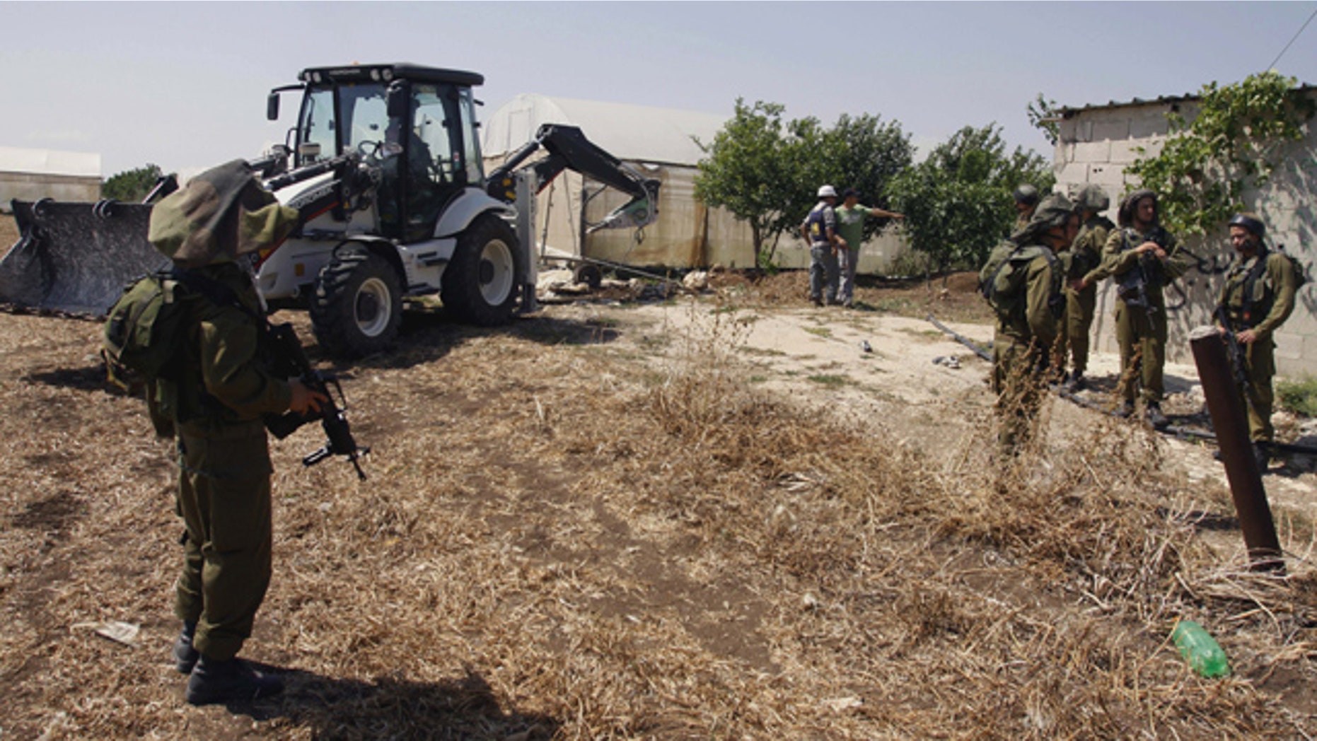 May 29: Israeli soldiers guard as a military tractor destroy wells used by Palestinian farmers for agricultural irrigation near the West Bank village of Kfar Dan west of Jenin.
