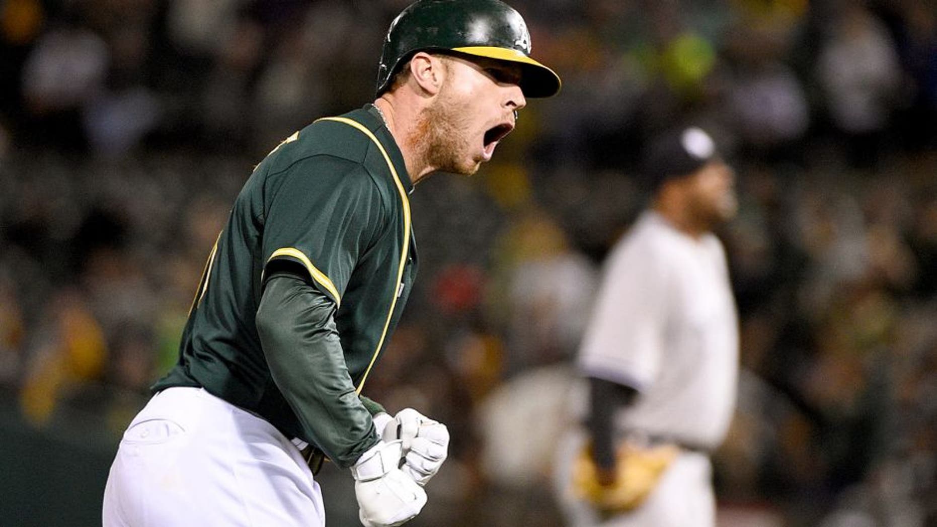 May 28, 2015; Oakland, CA, USA; Oakland Athletics third baseman Brett Lawrie (15, left) celebrates after hitting a two-run home run during the sixth inning against New York Yankees starting pitcher CC Sabathia (52, right) at O.co Coliseum. Mandatory Credit: Kyle Terada-USA TODAY Sports