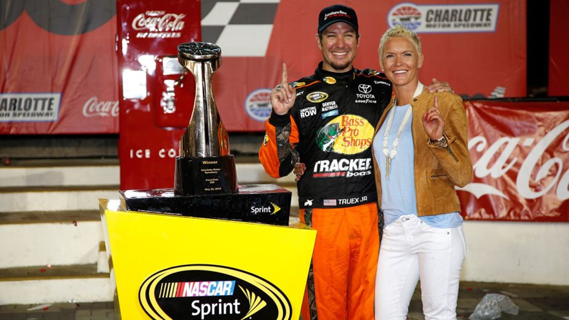 CHARLOTTE, NC - MAY 29: Martin Truex Jr., driver of the #78 Bass Pro Shops/Tracker Toyota, and his girlfriend Sherry Pollex pose with the trophy in Victory Lane after winning the NASCAR Sprint Cup Series Coca-Cola 600 at Charlotte Motor Speedway on May 29, 2016 in Charlotte, North Carolina. (Photo by Todd Warshaw/NASCAR via Getty Images)