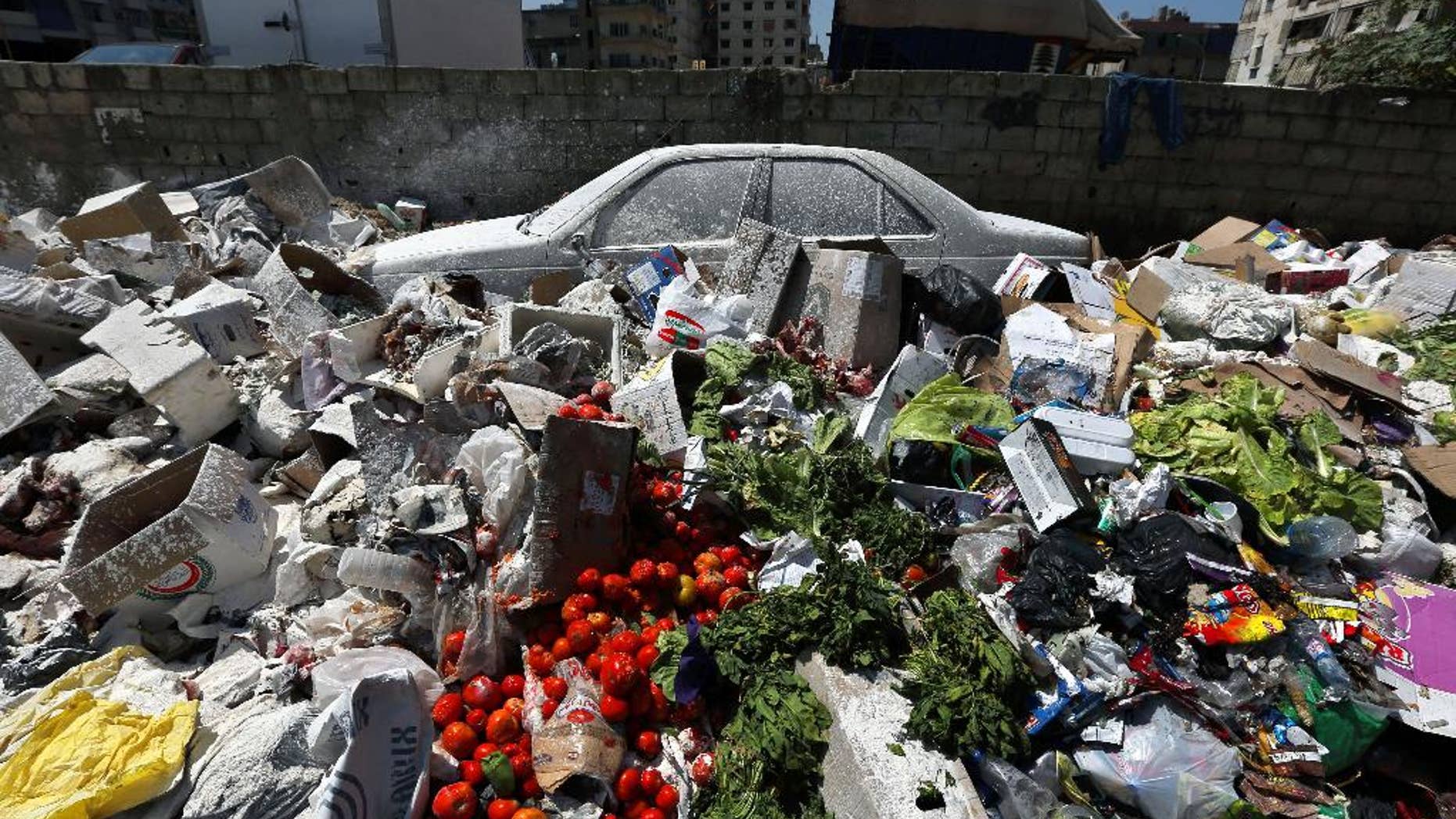 A car is seen between a pile of garbage covered with white pesticide in the Palestinian refugee camp of Sabra in Beirut, Lebanon, Thursday, July 23, 2015. The Lebanese cabinet has failed to agree on a solution for the country’s growing garbage crisis, postponing discussion until next week as trash piles up on the streets. (AP Photo/Bilal Hussein)
