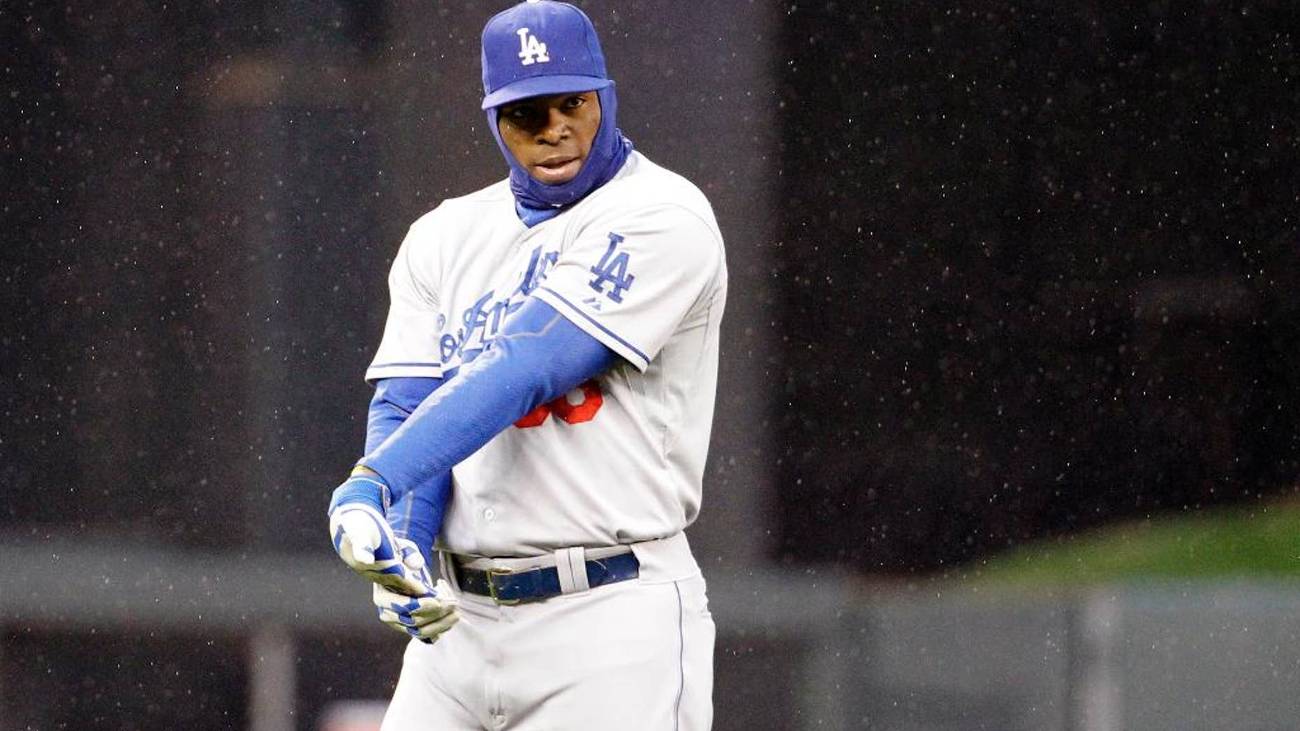 Los Angeles Dodgers right fielder Yasiel Puig warms up in a light rain before the first inning of a baseball game against the Minnesota Twins in Minneapolis, Wednesday, April 30, 2014. (AP Photo/Ann Heisenfelt)