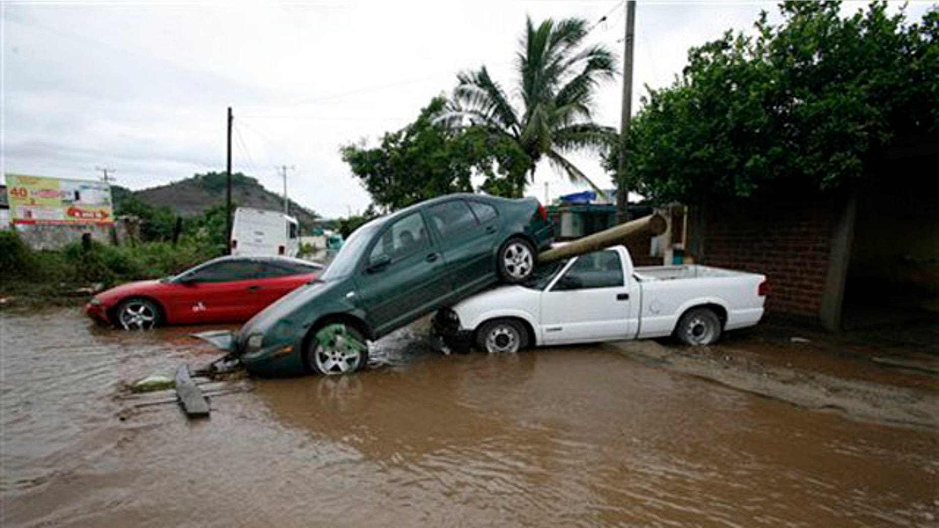Cars pile up after being dragged by flood waters in Villa de Coral, Mexico, Wednesday Oct. 12, 2011.