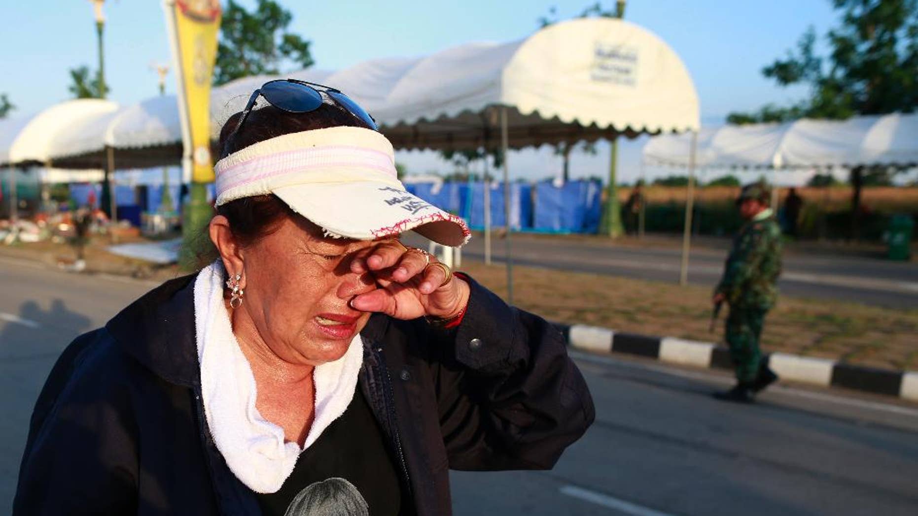 A pro-government demonstrator cries as she leaves a demonstration site after soldiers staged a coup Thursday, May 22, 2014 on the outskirts of Bangkok, Thailand. Thailand's new military junta has announced that it has suspended the country's constitution. A military statement broadcast on national television Thursday confirmed the nation's caretaker government is no longer in power but said the Senate will remain in place. (AP Photo/Wason Wanichakorn)