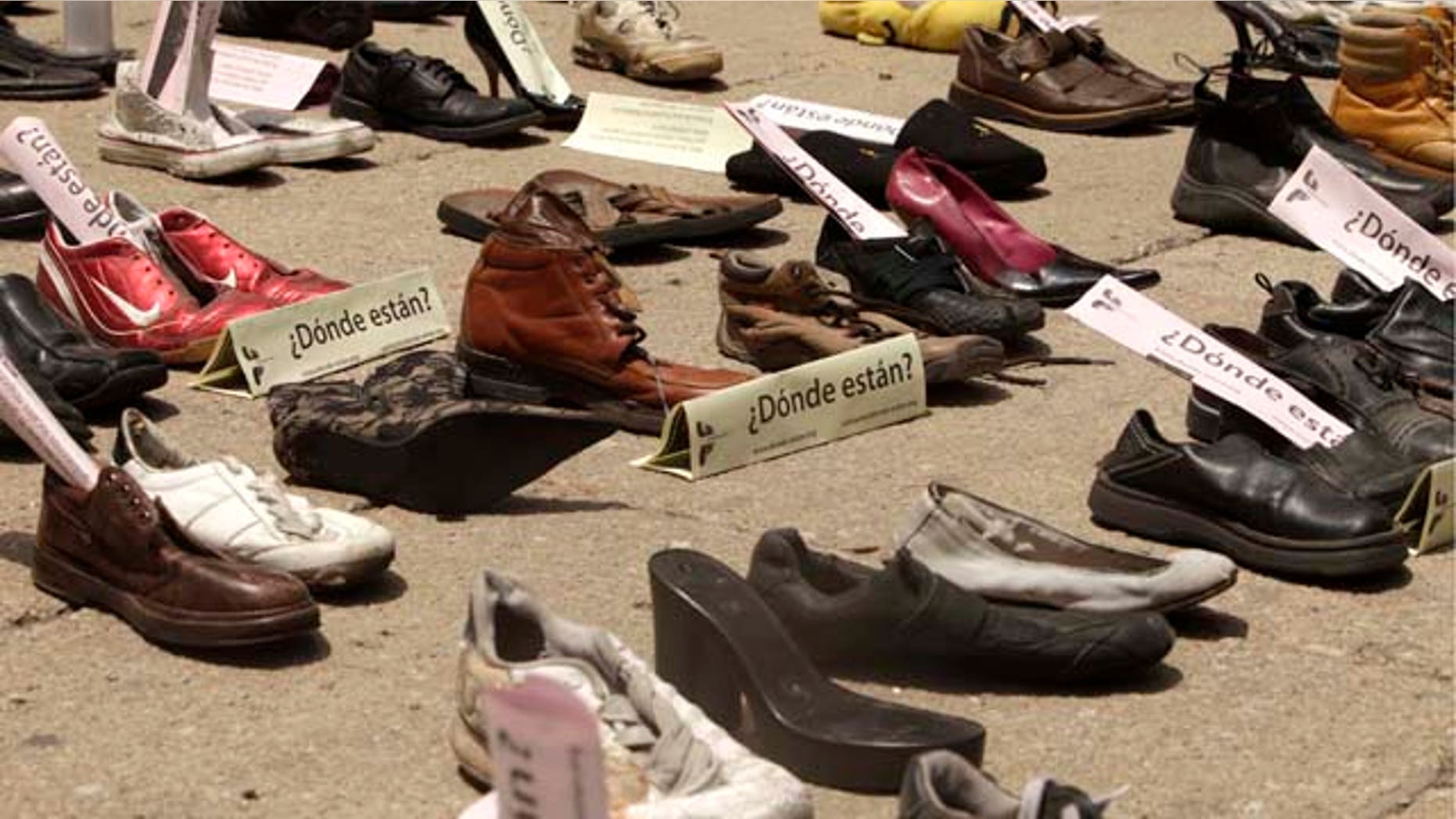 Shoes with signs that read in Spanish: "Where are them?" are displayed right outside the Senate building during a demonstration to protest against violence in Mexico City, Sunday Aug. 14, 2011. The continuing tide of drug-related killings in Mexico has drawn thousands of protesters to march against violence. (AP Photo/Arnulfo Franco)