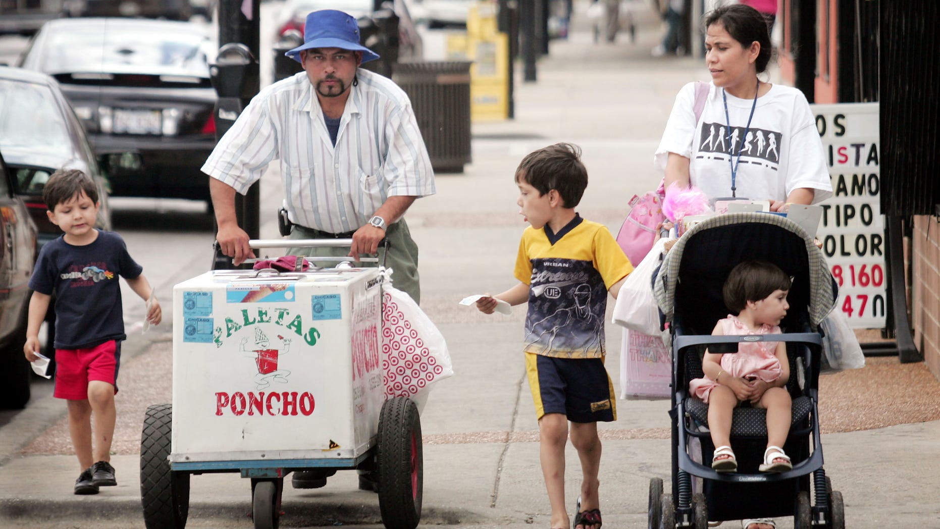 CHICAGO - JUNE 14: Residents walk past a paleta vendor along 26th Street in the predominantly Mexican Little Village neighborhood June 14, 2005 in Chicago, Illinois. According to the U.S. census Hispanics accounted for approximately half of the national population growth between July 1, 2003 and July 1, 2004 now accounting for one-seventh of the population. (Photo by Scott Olson/Getty Images)