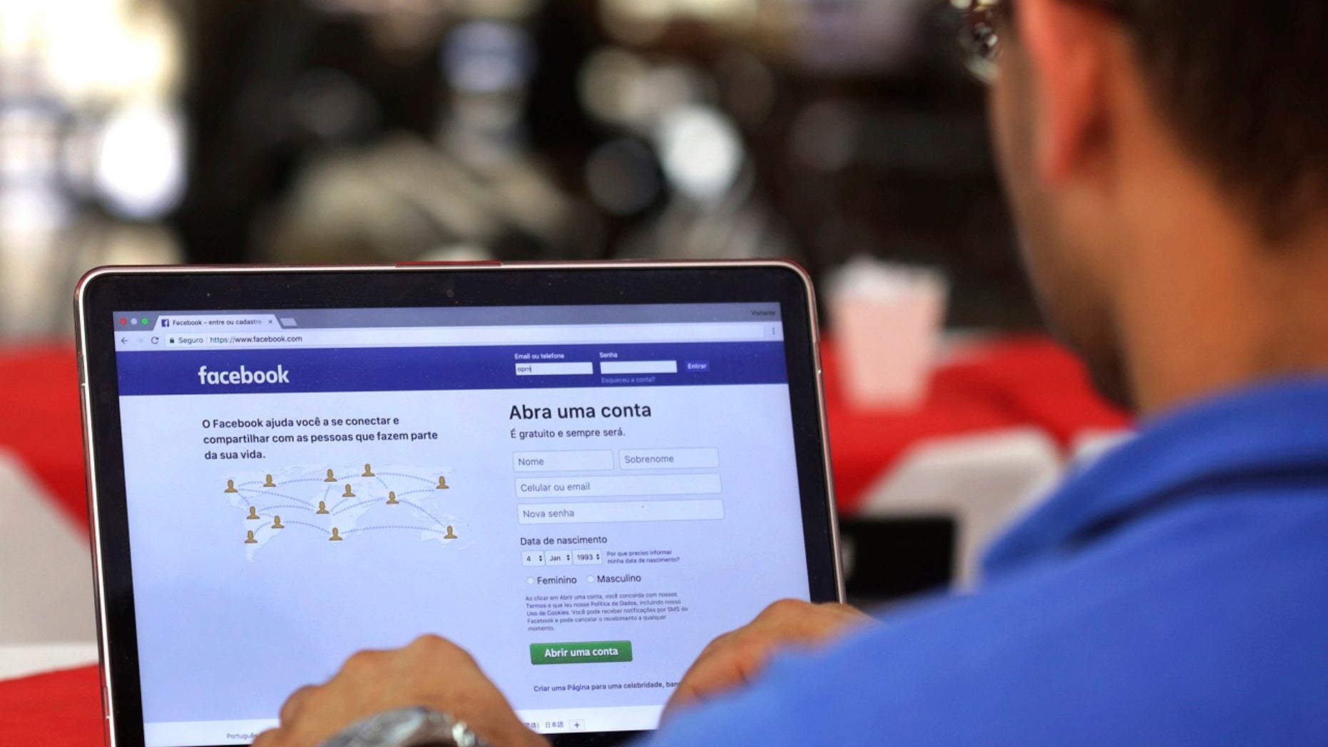 FILE - In this Thursday, Jan. 4, 2018, file photo, a man demonstrates how he enters his Facebook page as he works on his computer at a restaurant in Brasilia, Brazil. (AP Photo/Eraldo Peres, File)
