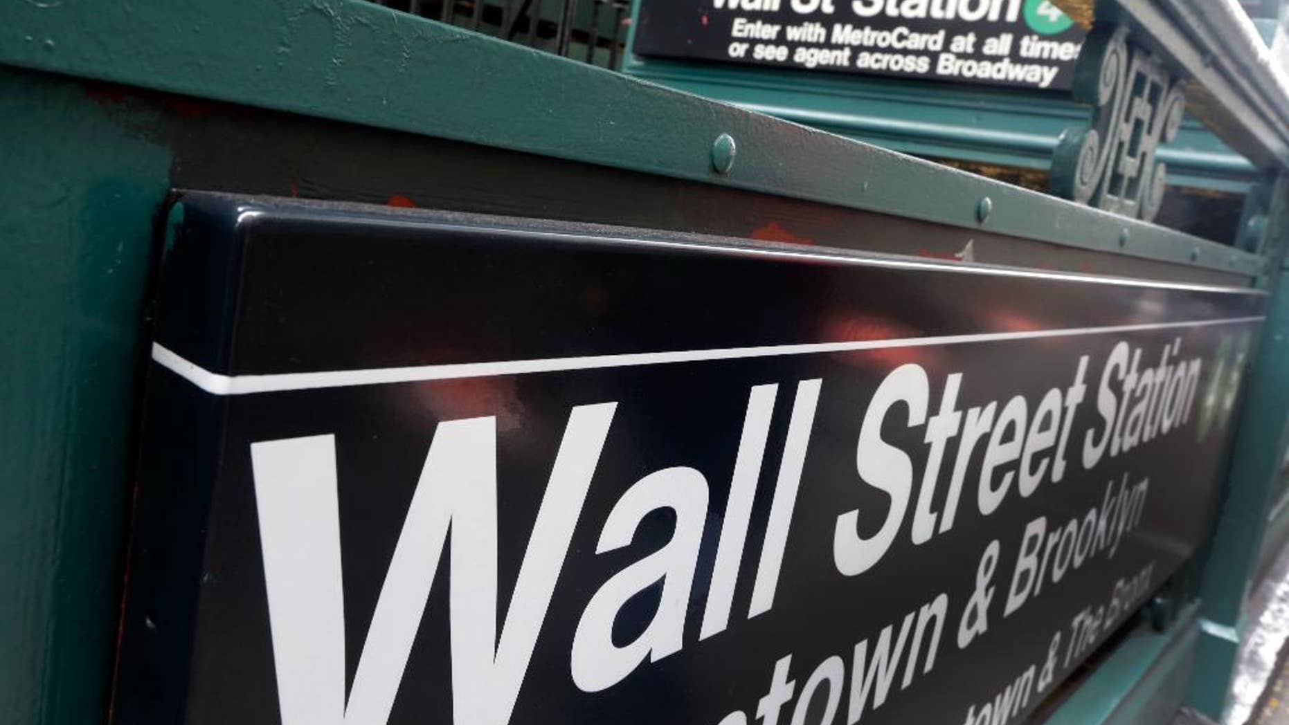 FILE-This Oct. 29, 2014 file photo shows the Wall Street subway stop on Broadway, in New York's Financial District. U.S. stocks are falling broadly in early trading on Friday, April 17, 2015, following steep declines in Europe and some results from big U.S. companies. Nine of the 10 industry groups of the Standard and Poor’s 500 are down, led by information technology companies. (AP Photo/Richard Drew)
