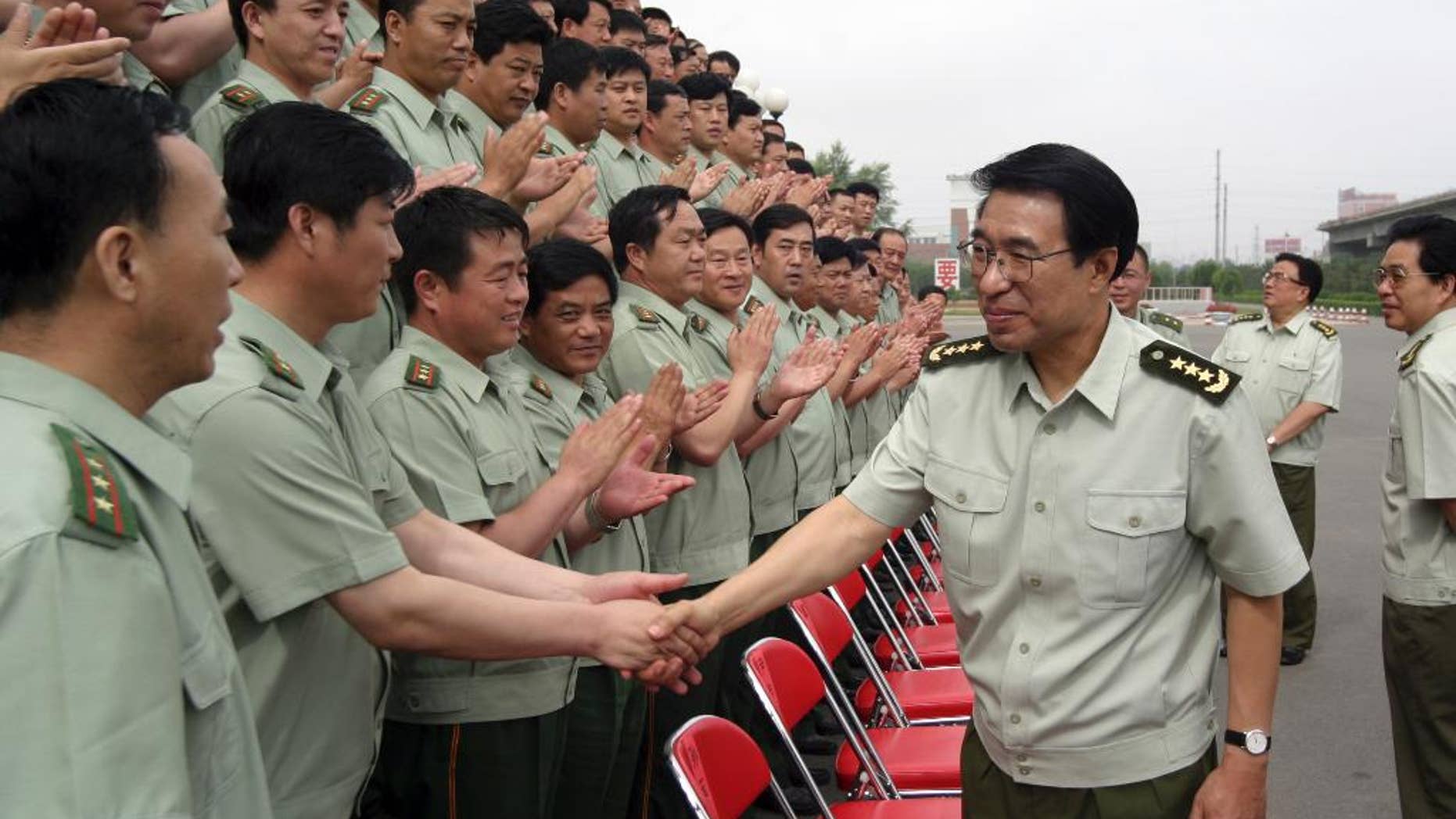 In this July 14, 2004 photo, Xu Caihou, then member of the Secretariat of the Communist Party of China Central Committee and Director-general of General Political Department? of the People's Liberation Army, shakes hands with members of the paramilitary force in Changchun in northeast China's Jilin province. Former No. 2 military official Xu, who was under investigation for alleged massive bribe-taking, has died in a hospital of cancer, the state Xinhua News Agency reported early Monday March 16, 2015. He was 71.(AP Photo) CHINA OUT