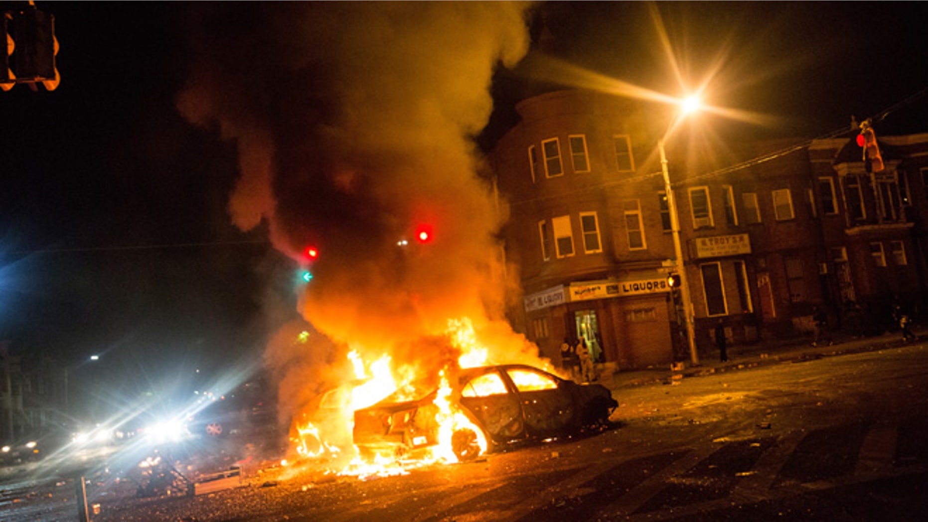 BALTIMORE, MD - APRIL 27: Two cars burn in the middle of an intersection at New Shiloh Baptist Church on April 27, 2015 in Baltimore, Maryland. Riots have erupted in Baltimore following the funeral service for Freddie Gray, who died last week while in Baltimore Police custody. (Photo by Andrew Burton/Getty Images)