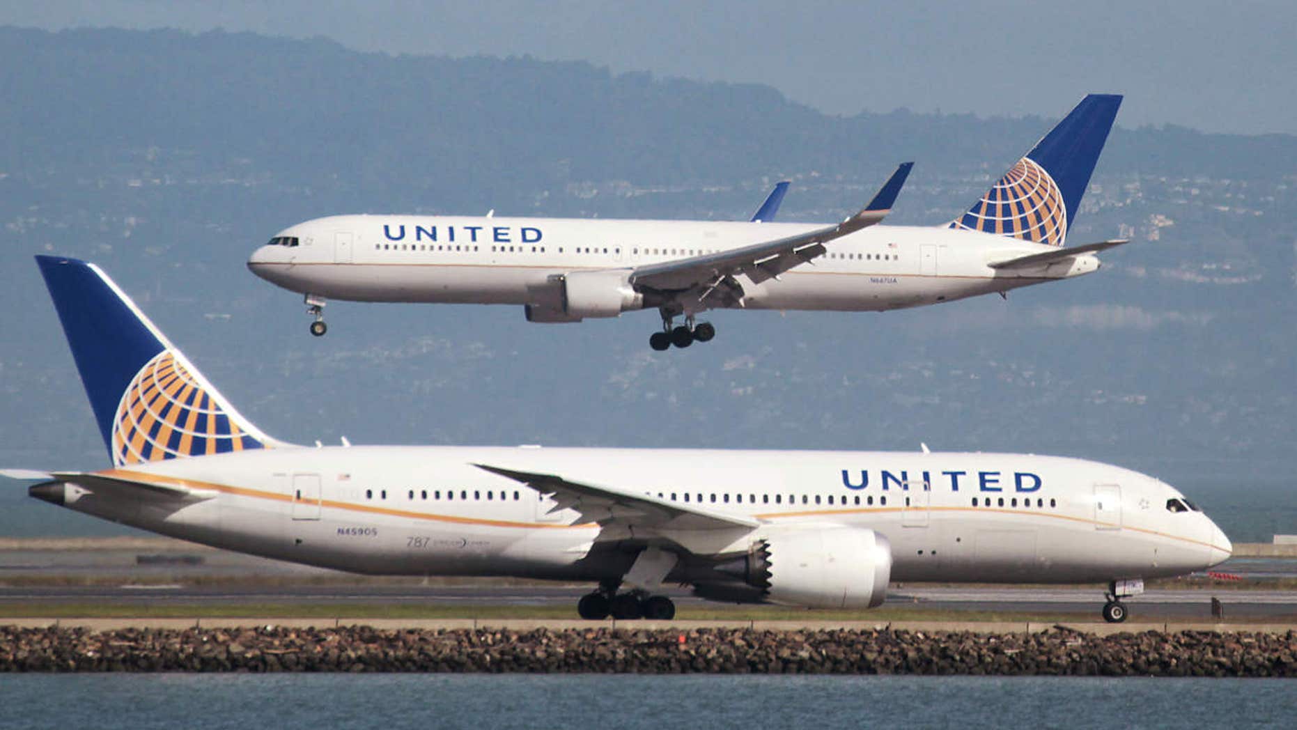 A United Airlines Boeing 787 taxis as a United Airlines Boeing 767 lands at San Francisco International Airport, San Francisco.