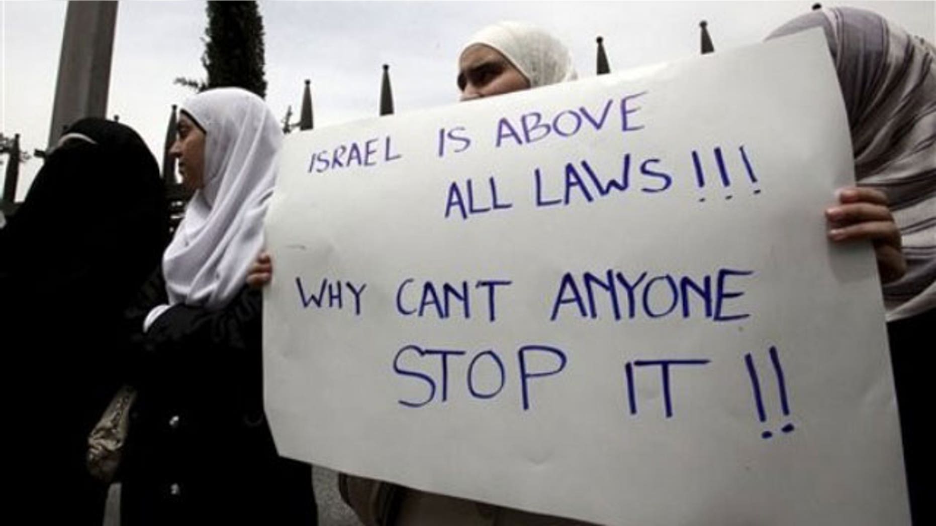 June 1: Jordanian students carry a banner during a rally in support of Turkey, in front of the University of Jordan in Amman, Jordan, after Monday's deadly commando raid by Israeli forces on ships taking humanitarian aid to the blockaded Gaza Strip. Poster reads 'Israel is above all laws, why can't anyone stop it' (AP).